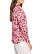 Pink, red, and dark blue Ikat-patterned cotton shirt.  Long sleeves, collared.  Circles are the main design element.