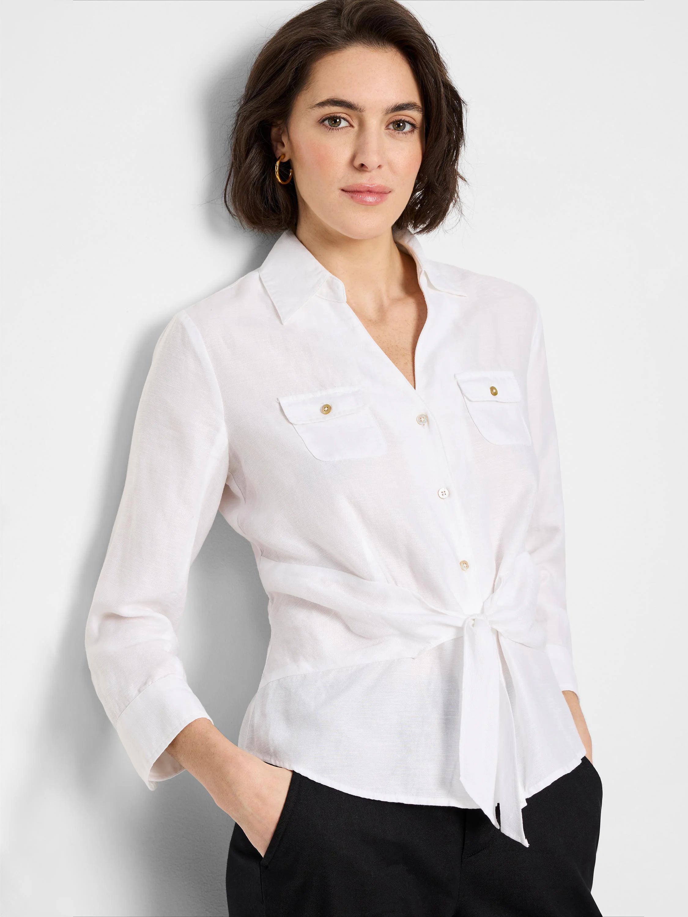 White linen shirt with three-quarter sleeves, button front, tie waist, and two chest pockets; gold buttons.