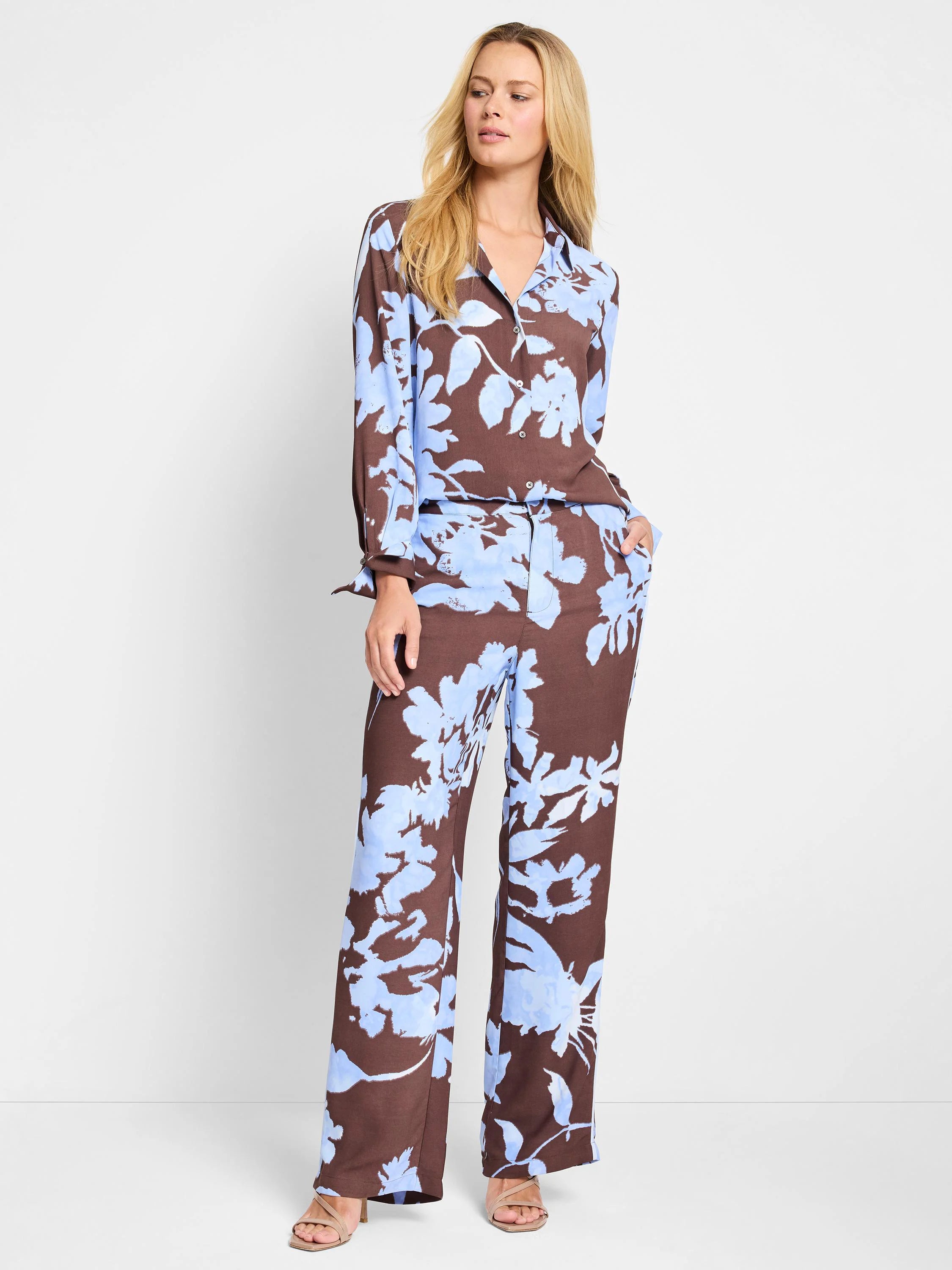 Brown woven top and pants with a light blue floral print. Long sleeves, collared top. Wide-leg pants.