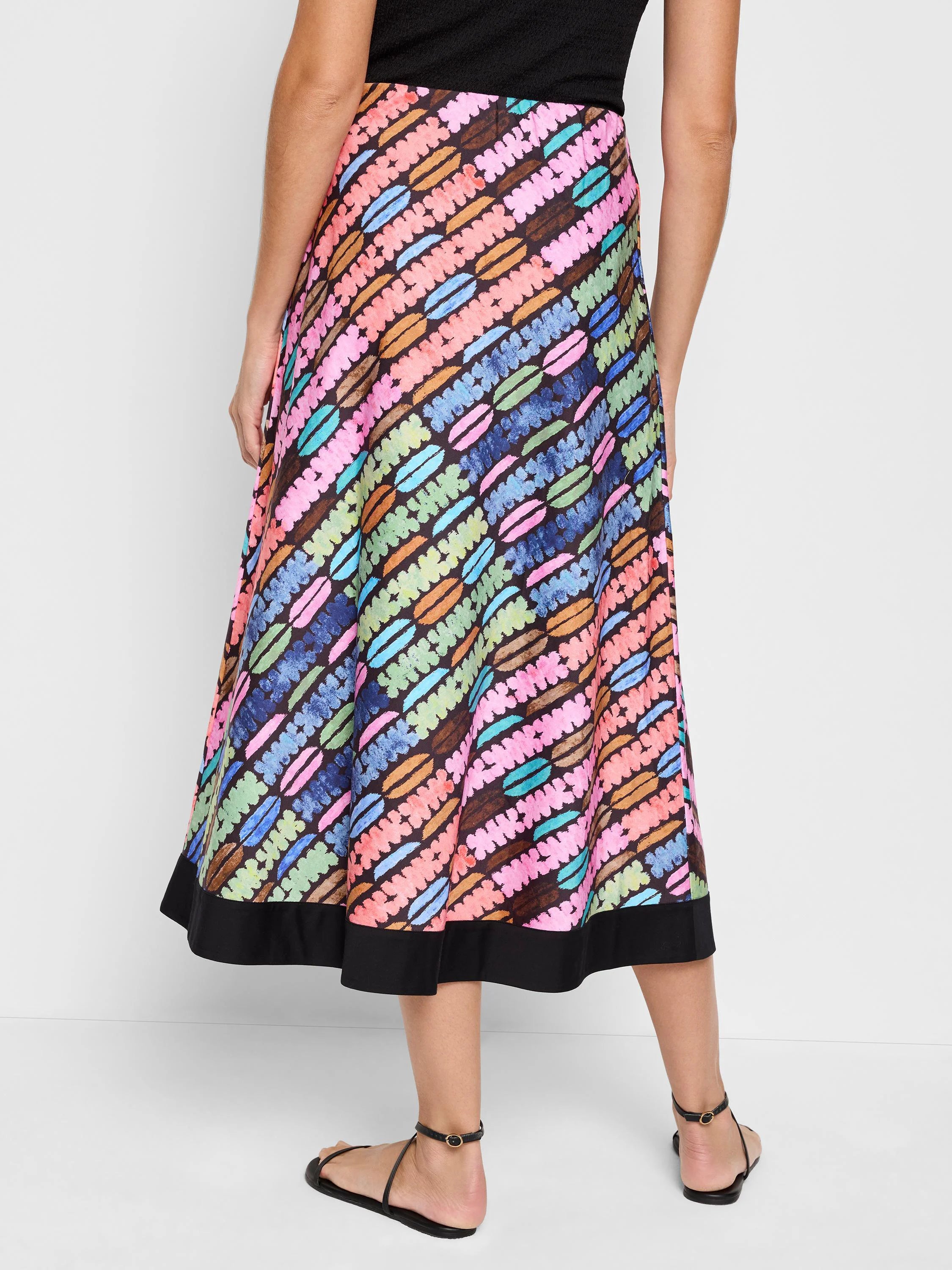A-line midi skirt in black background with diagonal rows of multicolored, pastel-colored oval shapes.  Black hem.