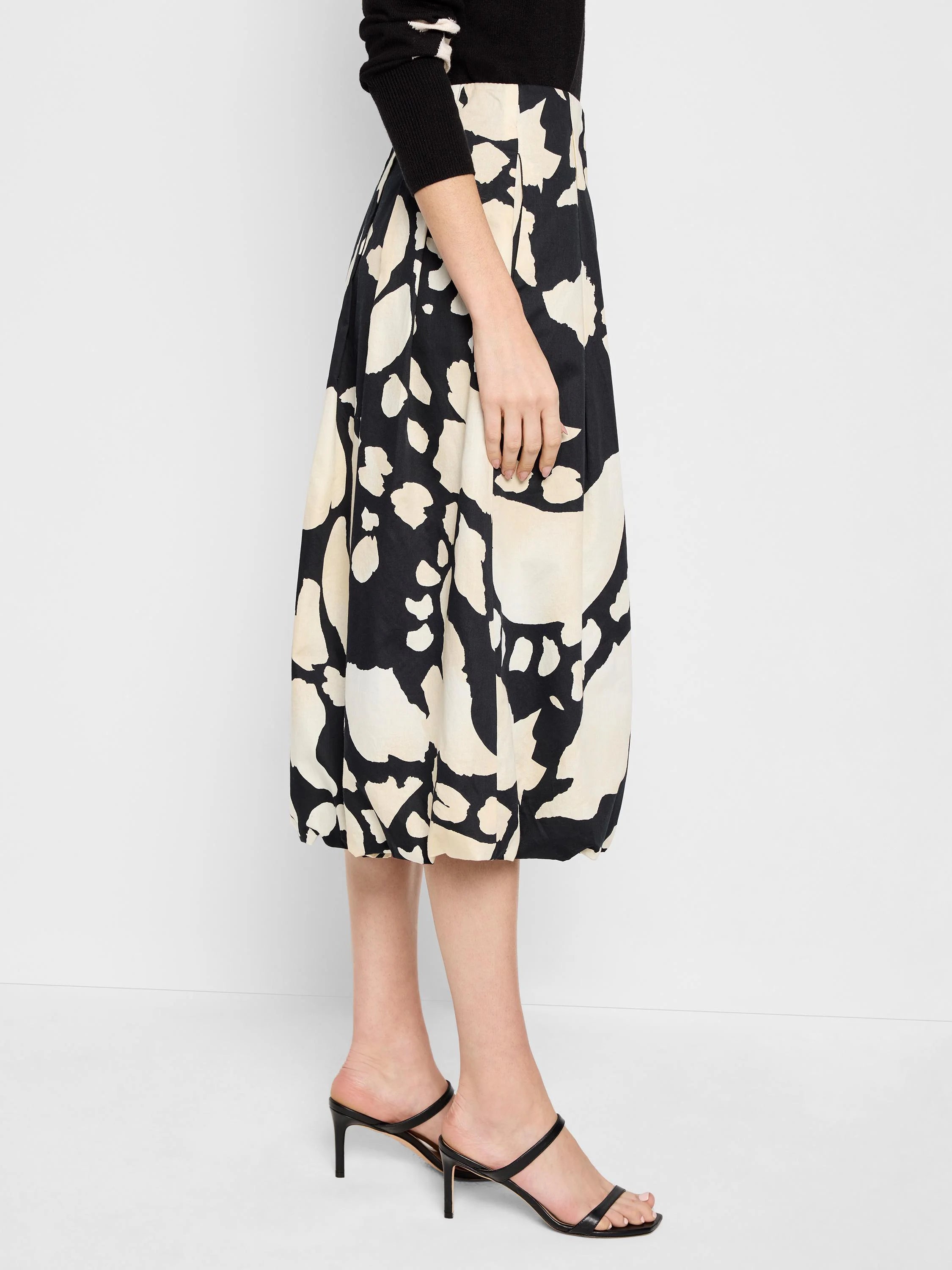 Black midi bubble skirt with an off-white abstract print. Pleated waist.