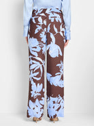 Brown wide-leg pants with a light blue floral print.  The print is an abstract watercolor style.