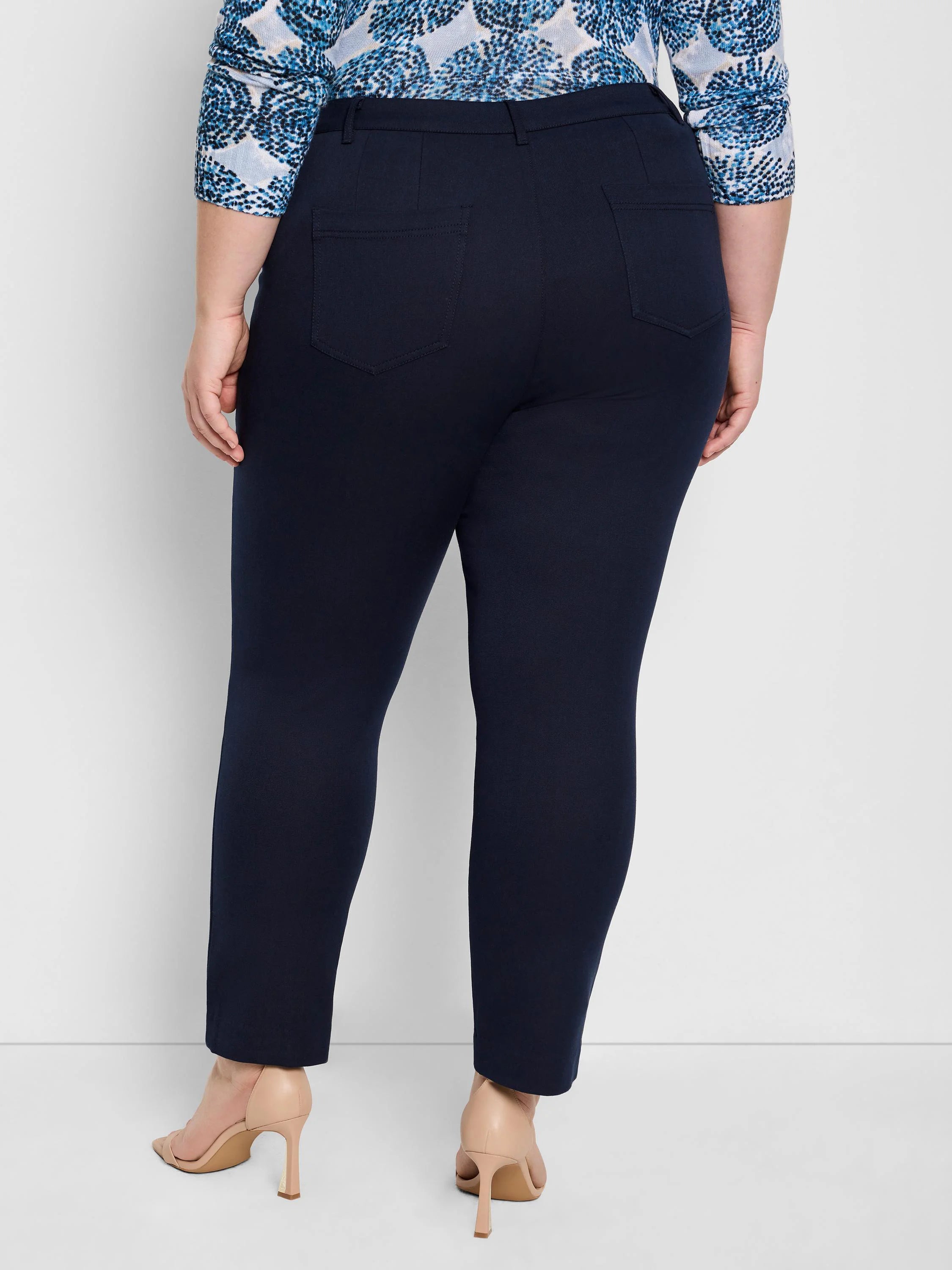 Dark navy blue straight pants with rear patch pockets, worn ankle-length.