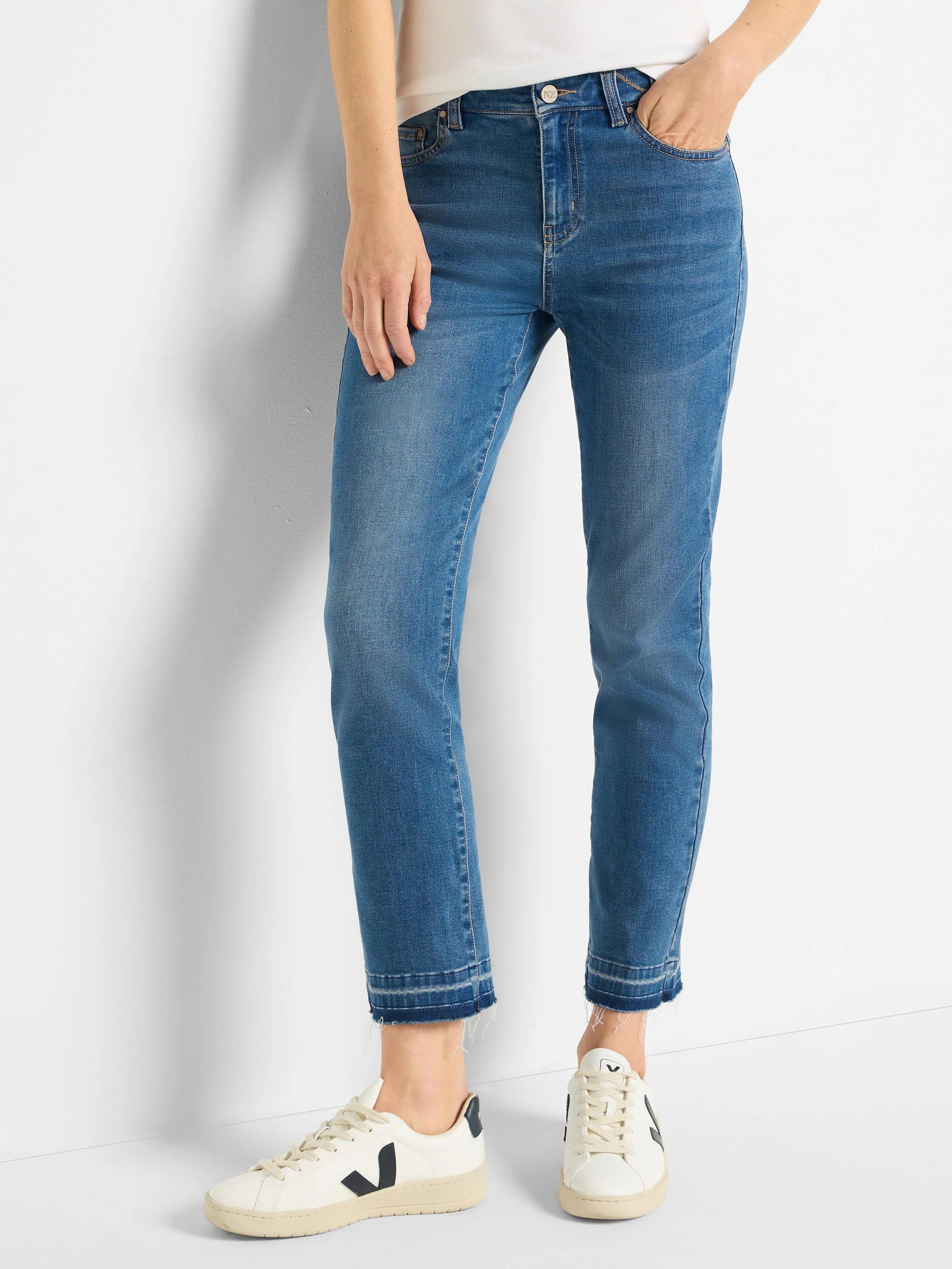 Medium blue straight-leg jeans, lighter wash, with a distinct light blue released hem showing slight fraying at the ankles.