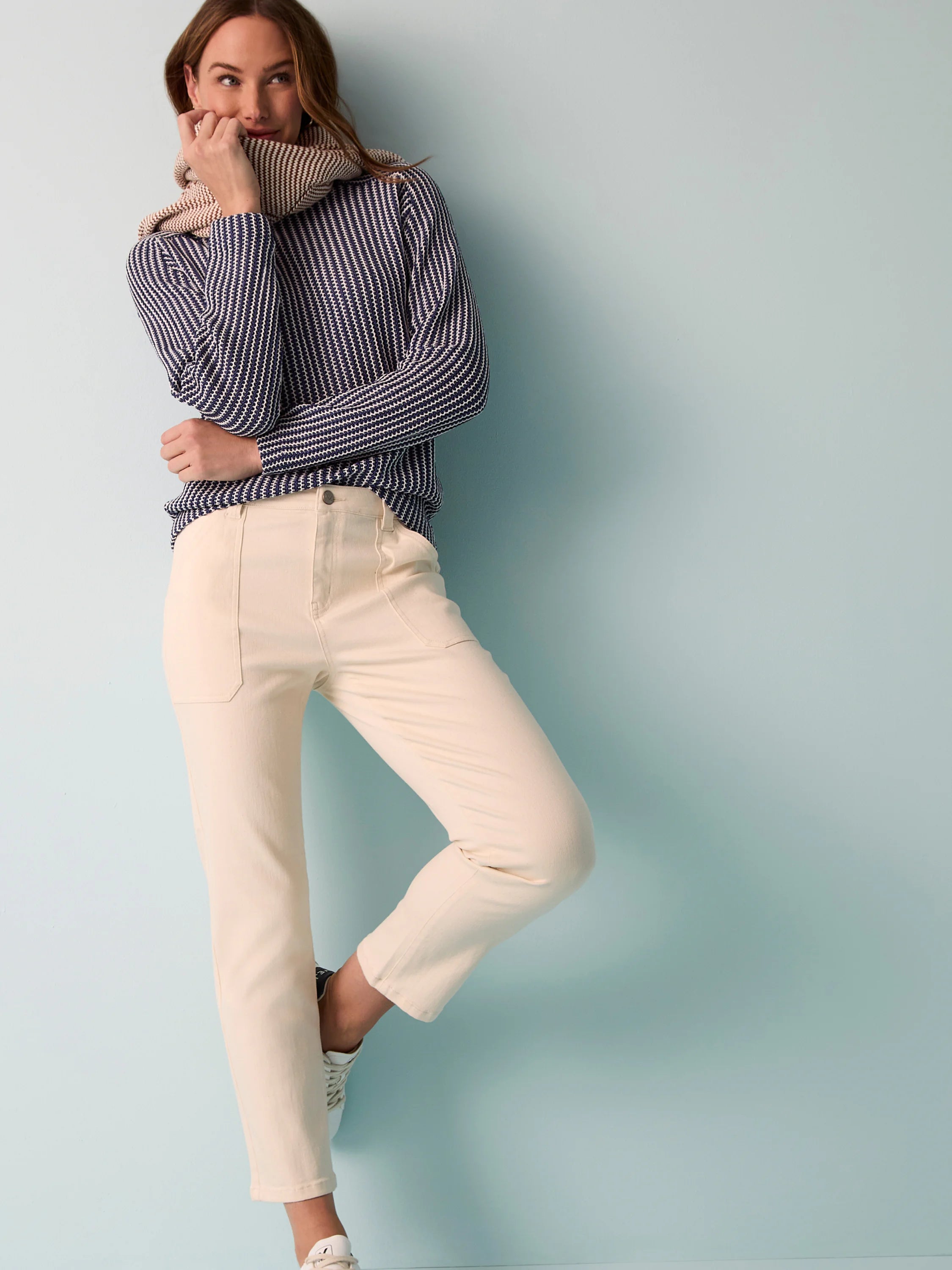 Cream-colored straight-leg jeans; model shown wearing them.