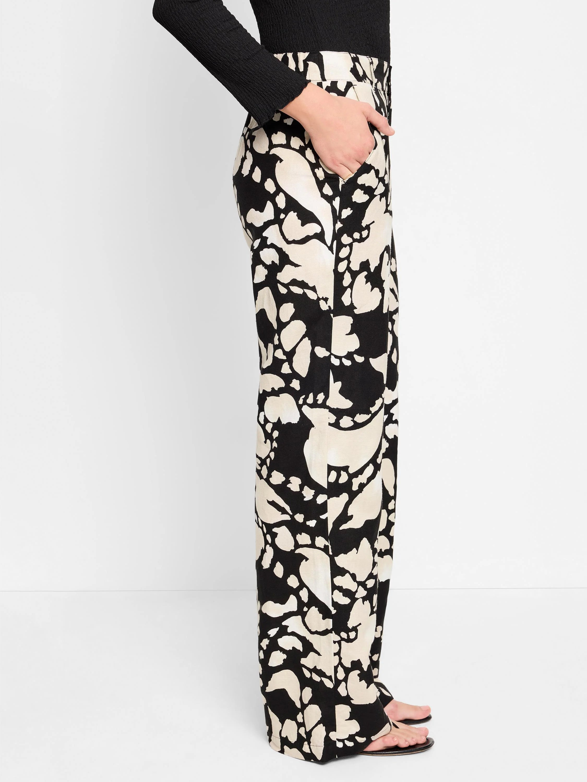 Black wide-leg pants with a beige abstract print.  Side view shows a center front seam and pockets.