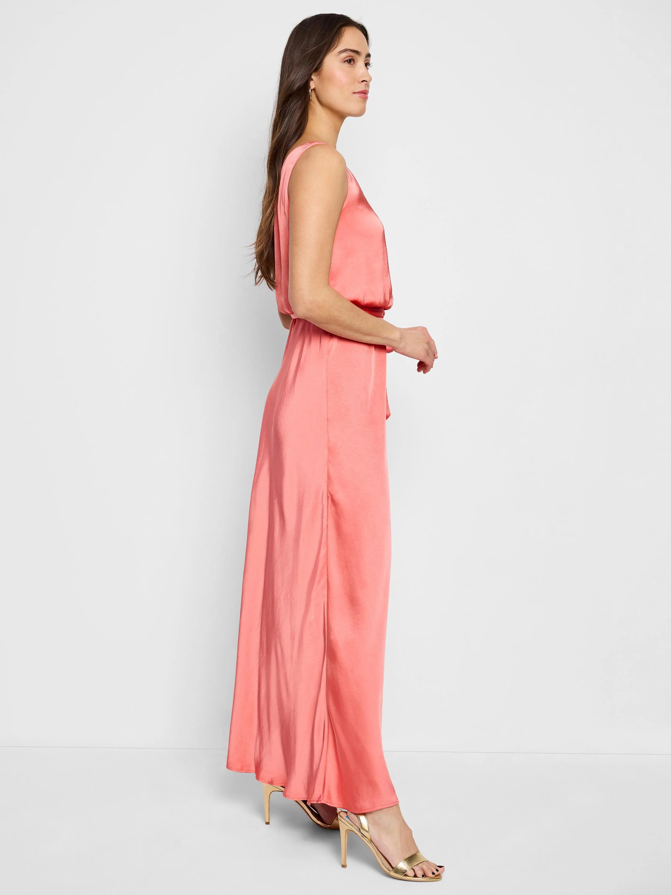 Coral pink, sleeveless maxi dress with a wrap bodice and self-tie belt. Floor-length, satin-like fabric.