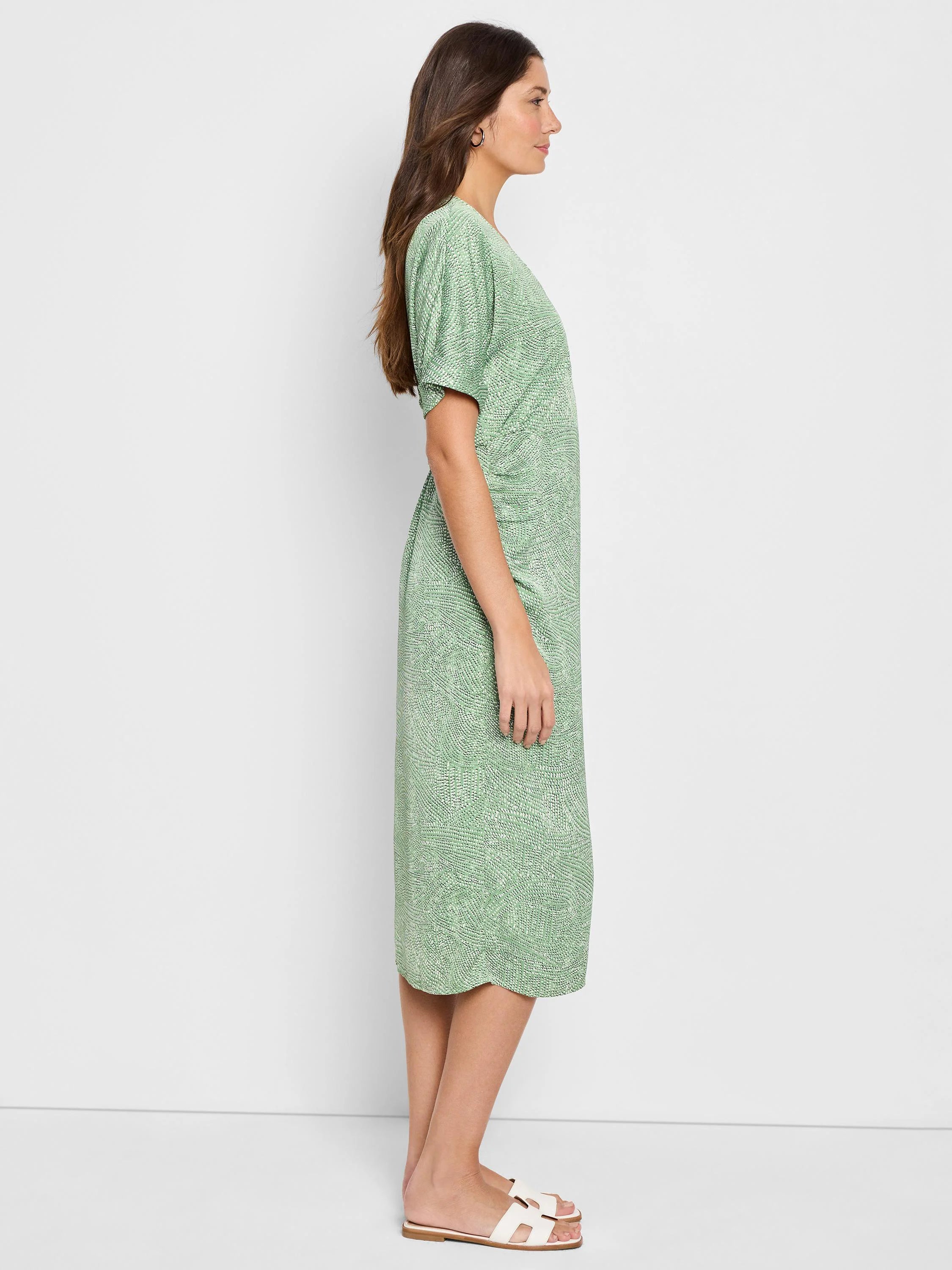 Light green midi dress with a white abstract print, short sleeves, and a fitted waist.