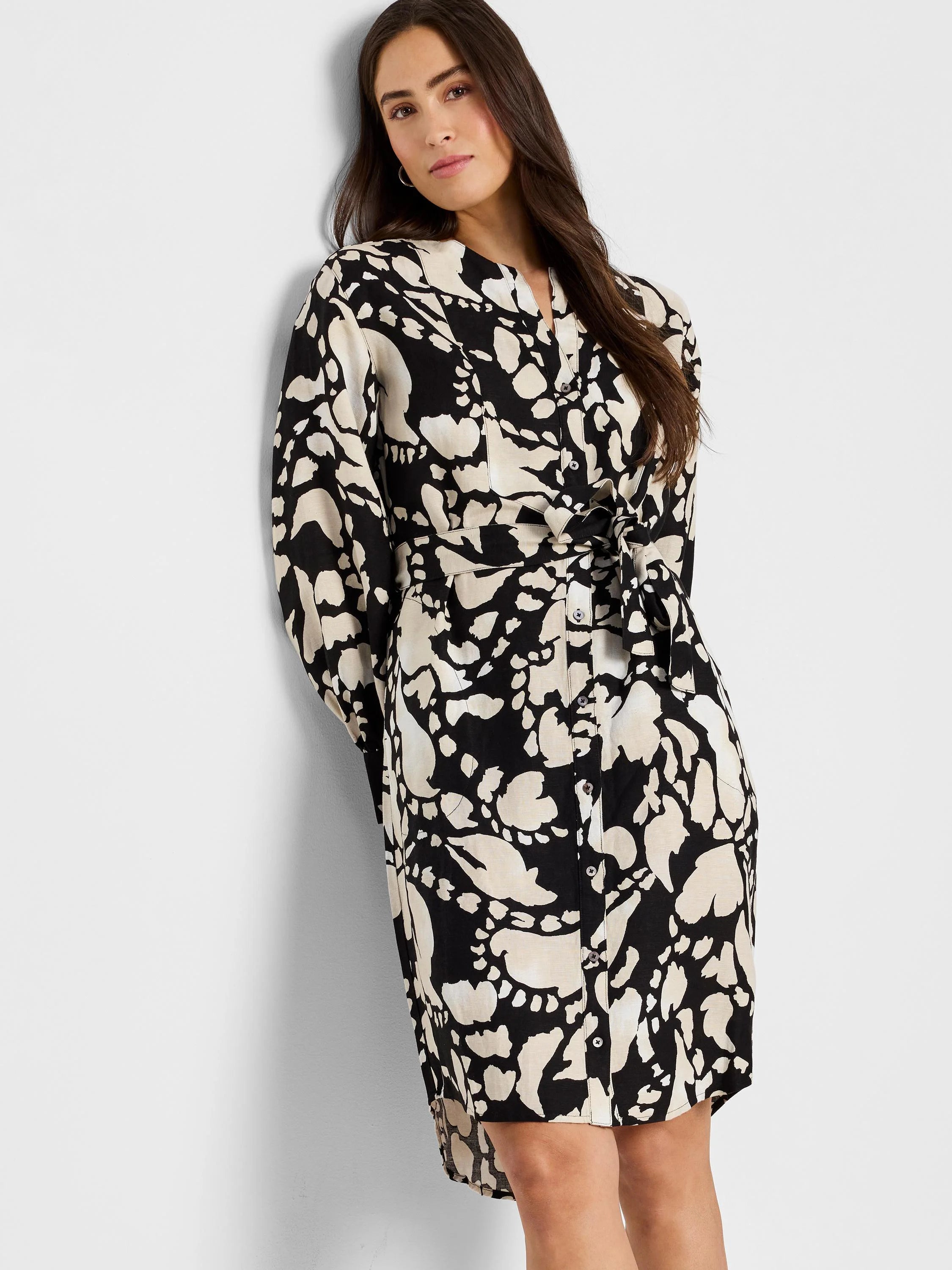 Black & beige abstract print shirt dress with long sleeves, button front, and self-tie belt. High-low hemline.