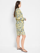Yellow shirt dress with a blue and black abstract print, knee-length, long sleeves, and a tie waist.