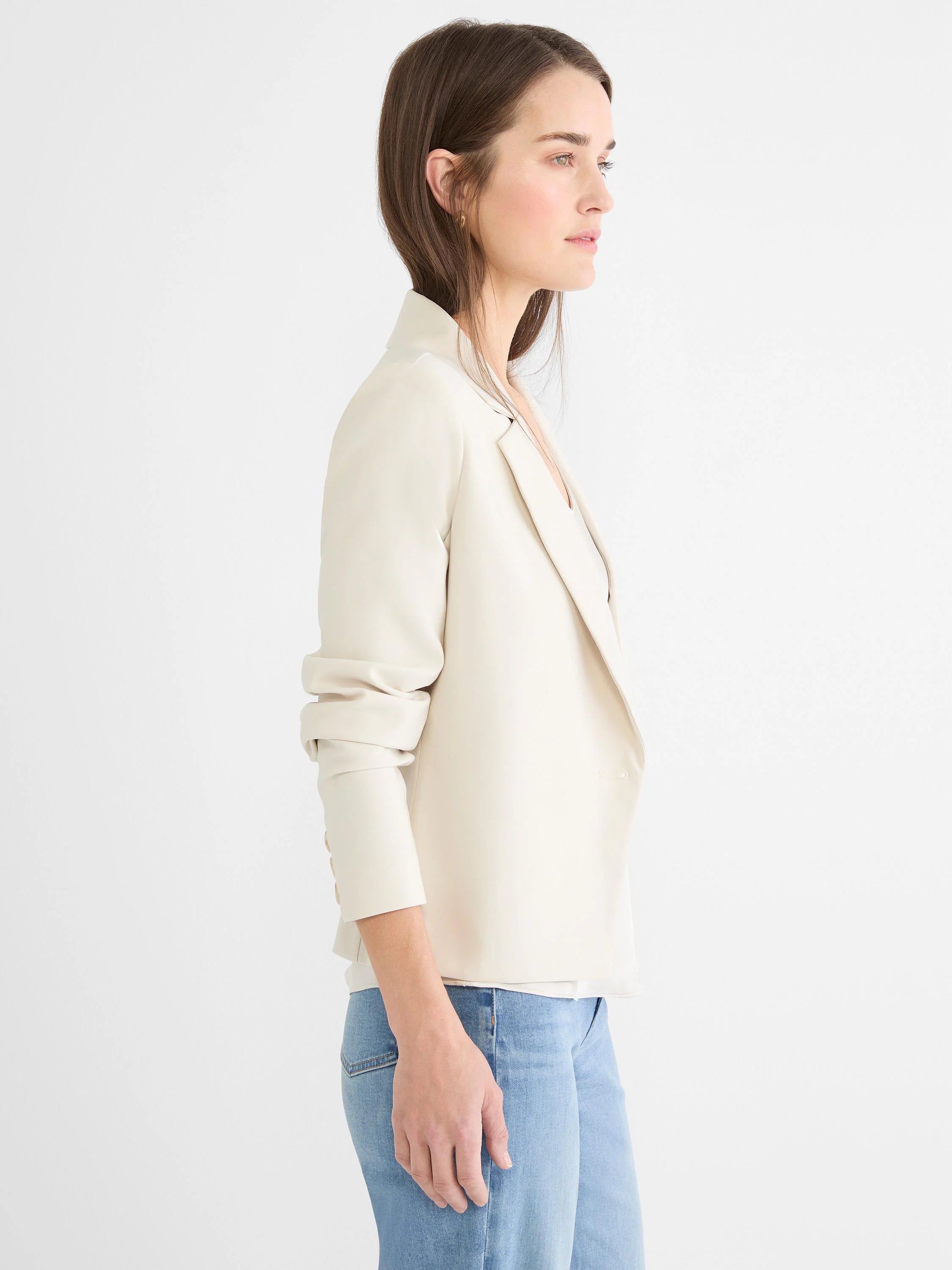 Light beige single-breasted blazer with narrow lapels and three cuff buttons.