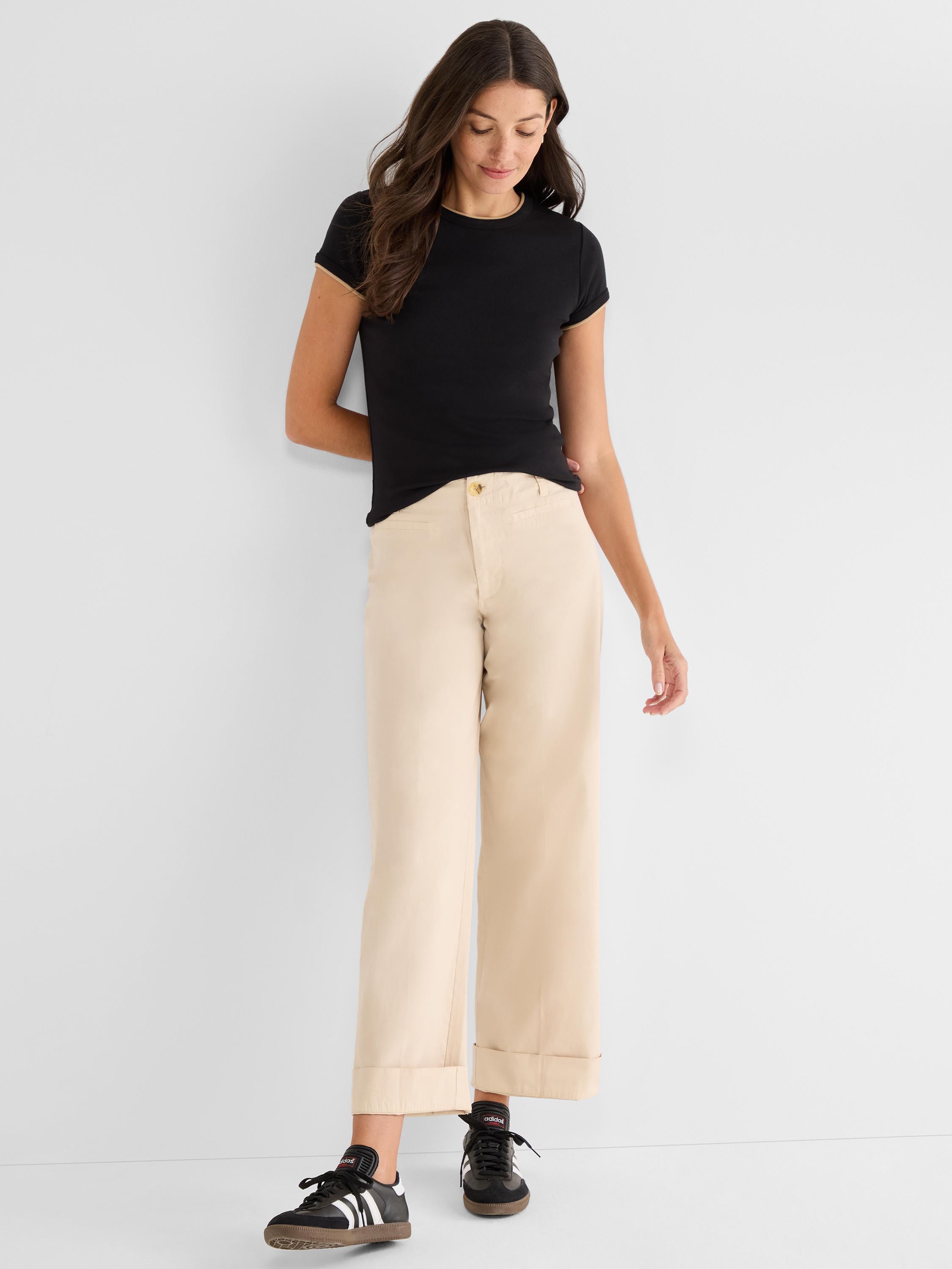 Fitted black ribbed tee and beige high-rise wide-leg trousers that are cropped and finished with thick cuffs.