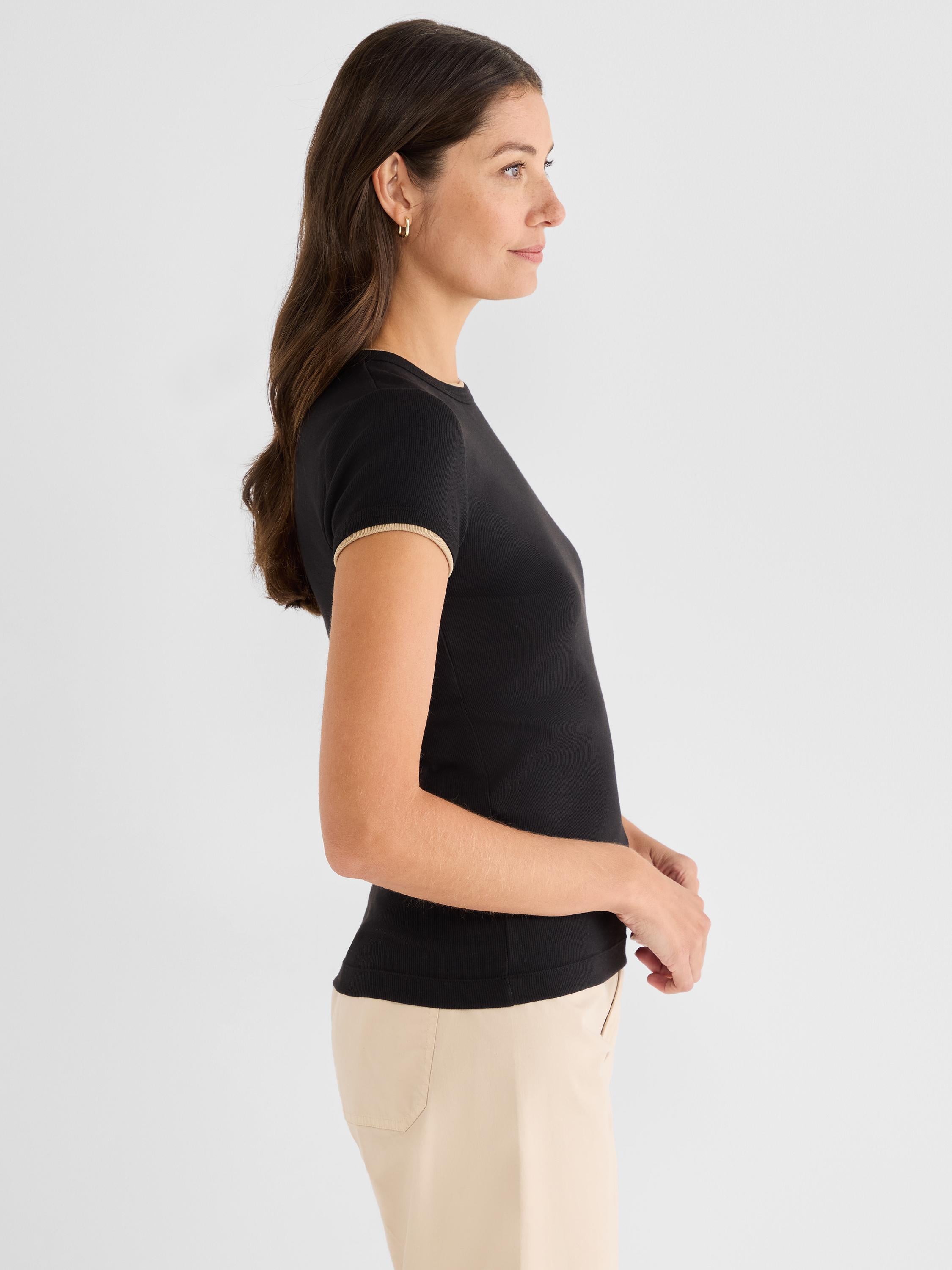 Fitted black ribbed knit top featuring short sleeves and contrasting tan ringer trim at the neck and cuffs.