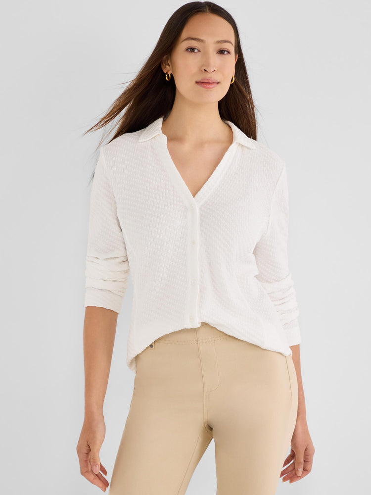 A relaxed off-white button-front shirt in a subtle textured knit, featuring a soft polo collar and long sleeves.