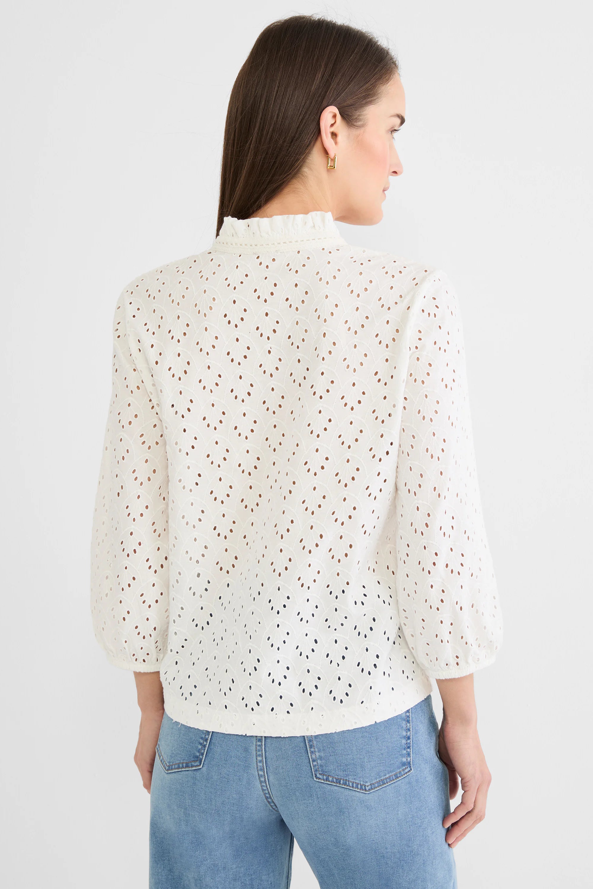 White eyelet knit top with ruffle mock neck, 3/4 puff sleeves, gathered cuffs, and a repeating leaf-like pattern.