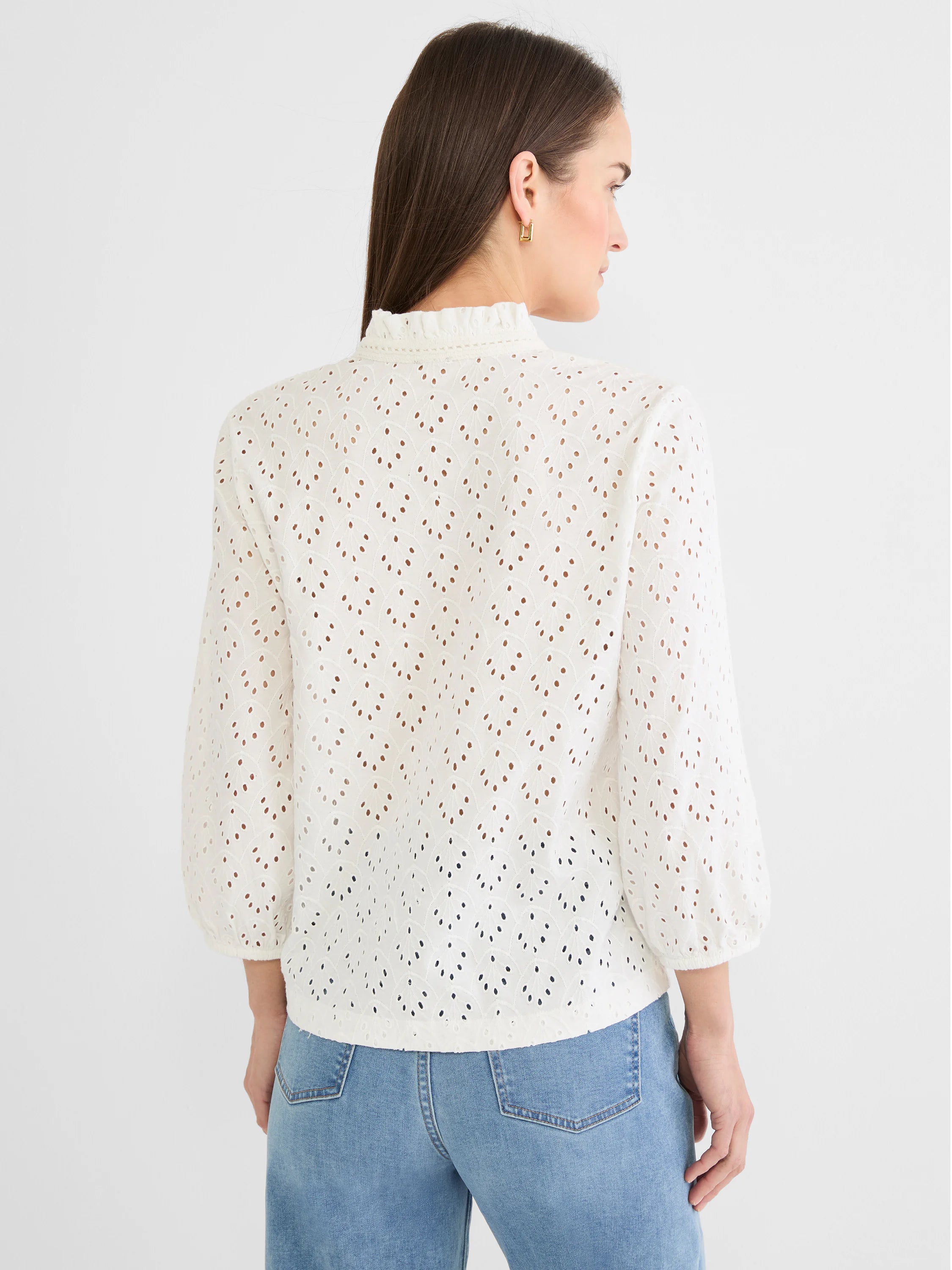 White eyelet knit top with ruffle mock neck, 3/4 puff sleeves, gathered cuffs, and a repeating leaf-like pattern.
