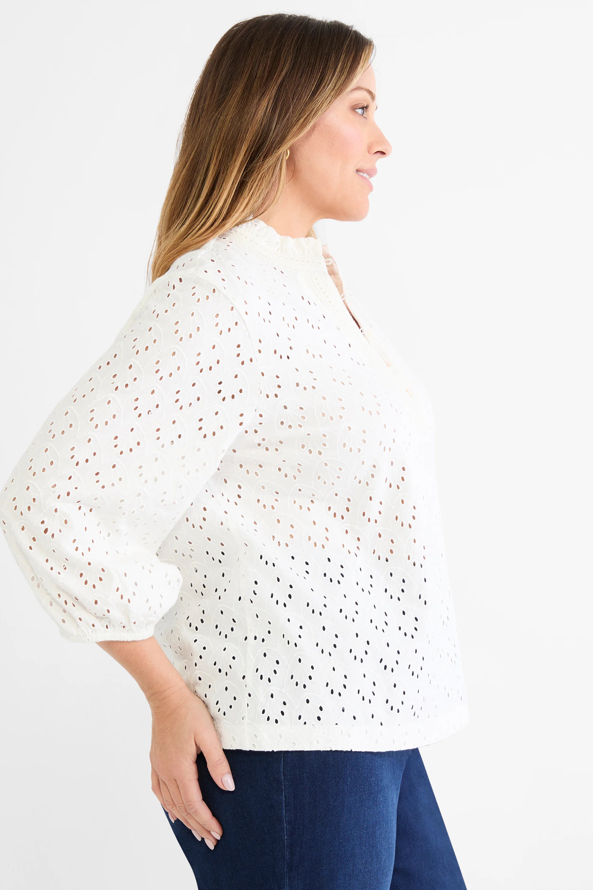 White knit top with leaf-pattern eyelets, a ruffled mock neck, and gathered 3/4 sleeves.