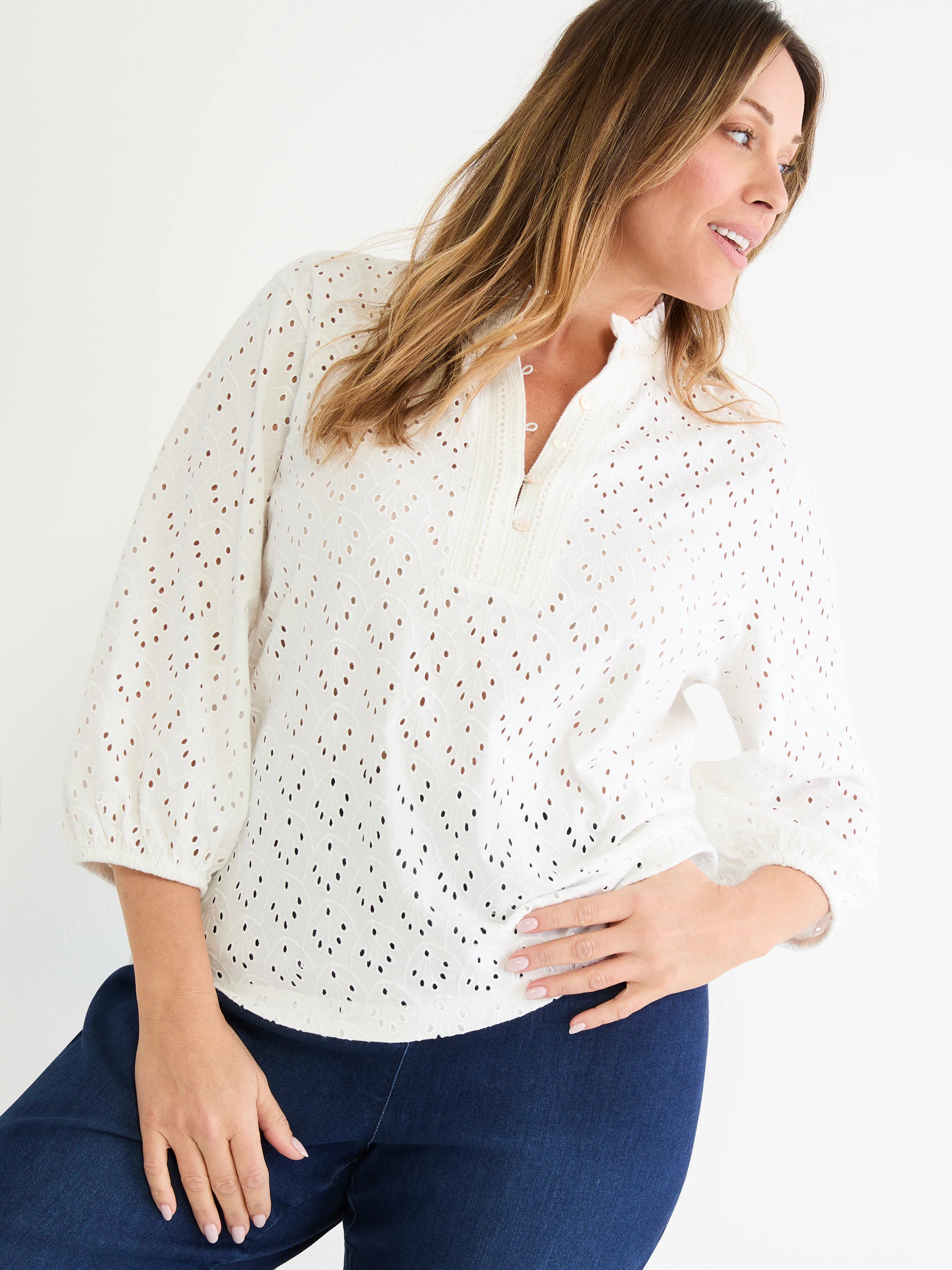White knit eyelet top with a ruffle neck, front button closure, and 3/4 sleeves with elastic cuffs.