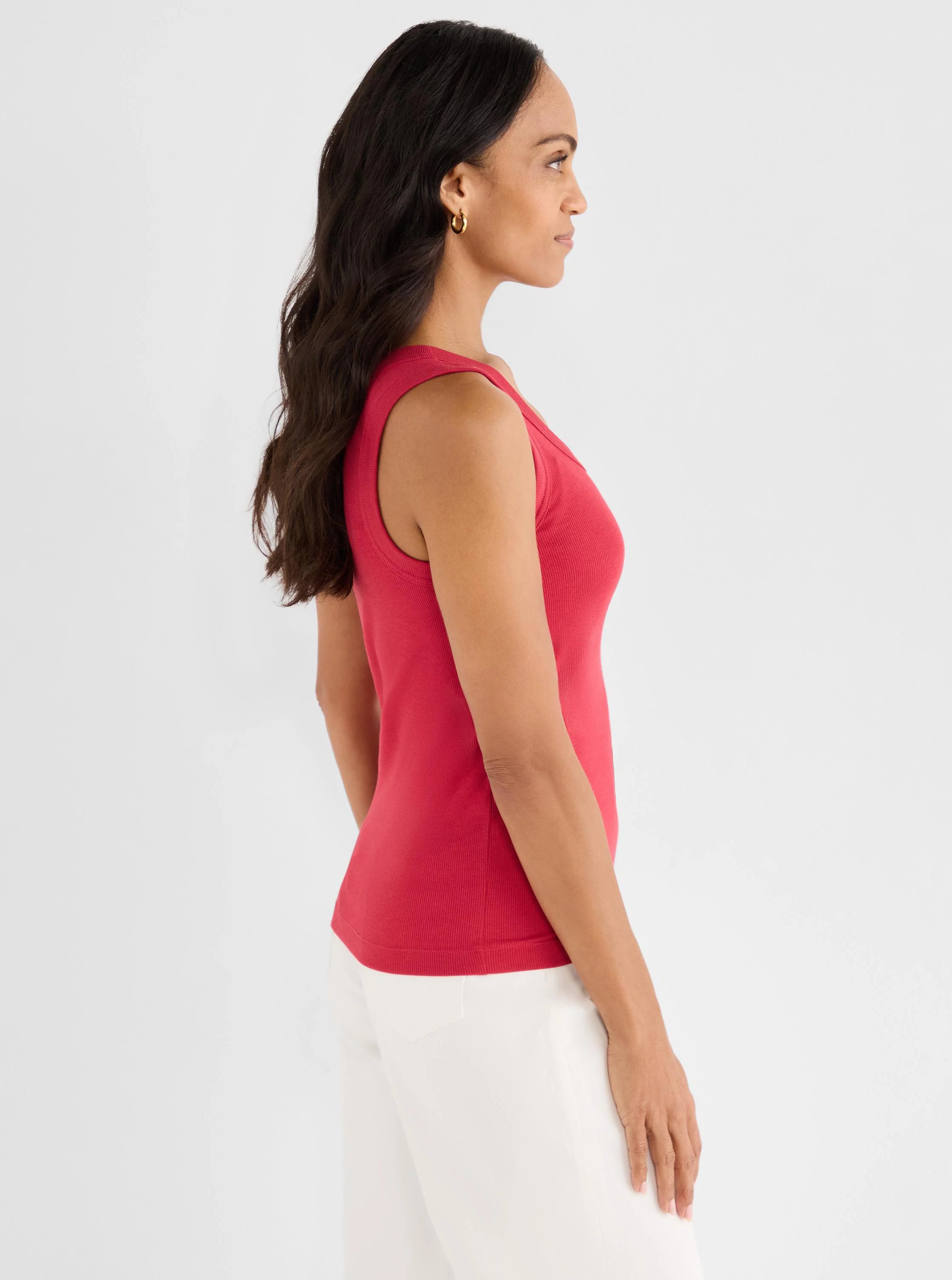 Raspberry pink ribbed scoop neck tank top on a model, shown from the side.