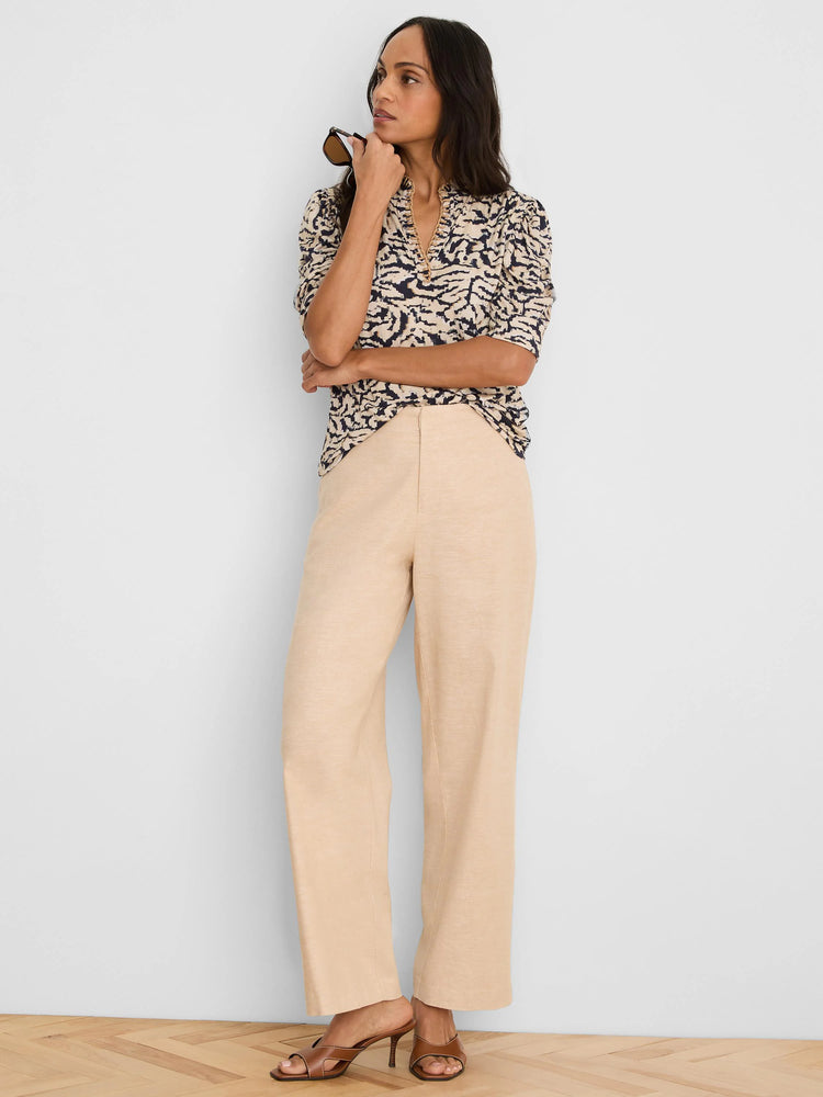 Beige V-neck top with dark swirling pattern and short puffed sleeves.