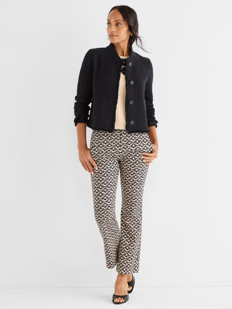 Black textured cropped jacket featuring frayed trim is paired with slim beige and black geometric print trousers.
