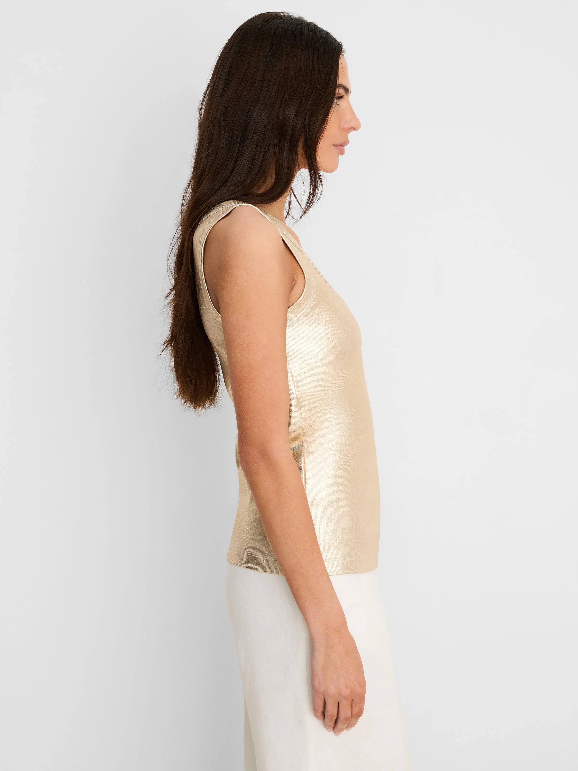Sleeveless metallic gold ribbed tank top with a subtle sheen, worn by a model in profile.