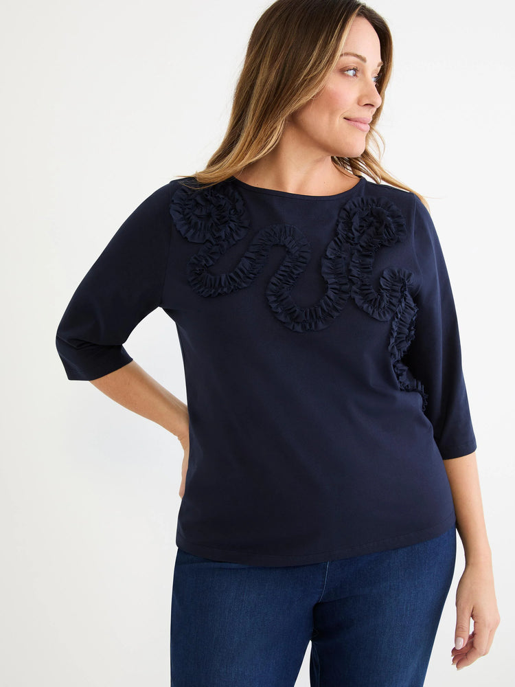 Dark navy boat neck top with 3/4 sleeves and self-color ruffled mesh appliqué across the chest.