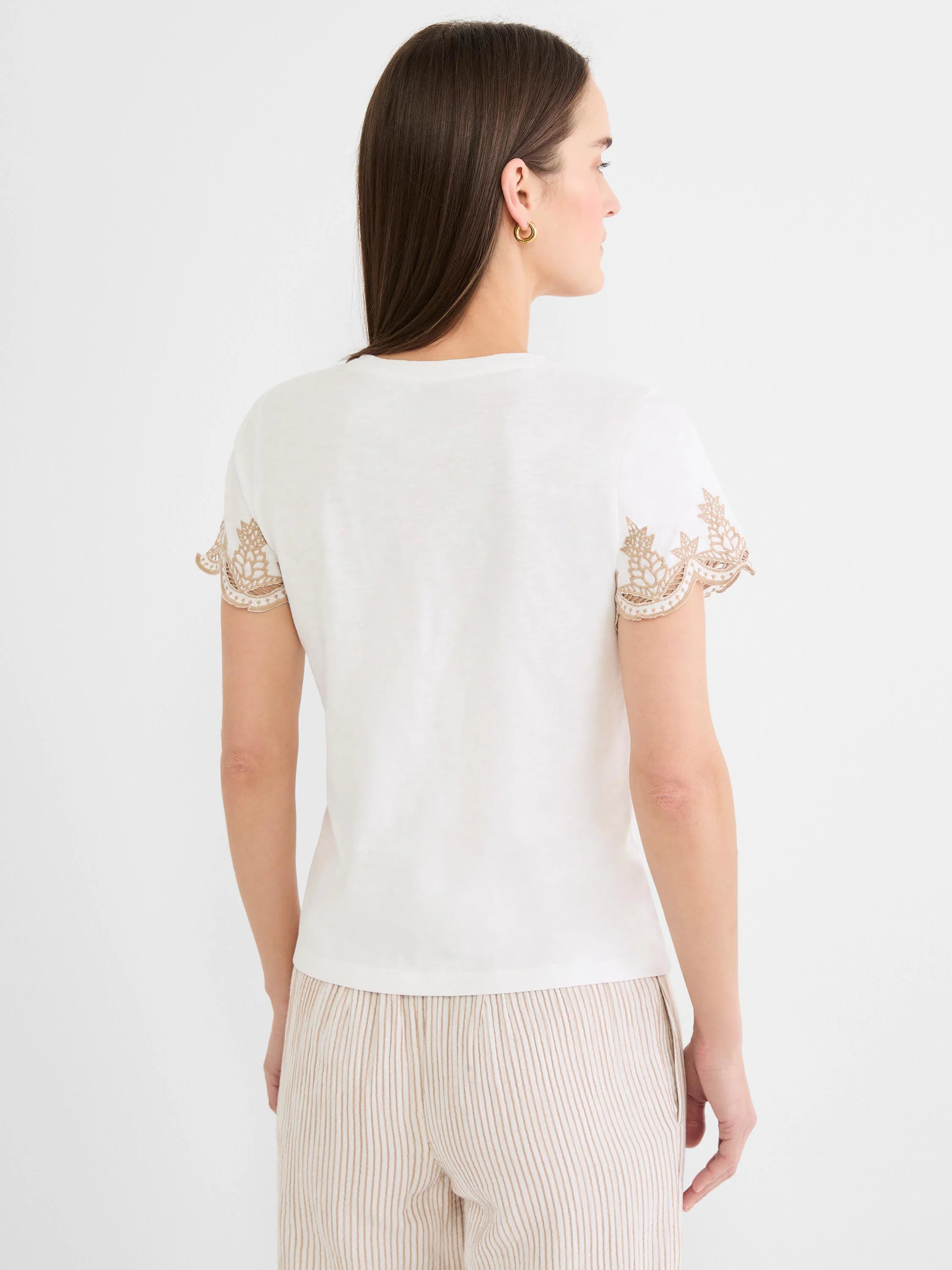 Ecru cotton slub tee with short sleeves featuring tan, ornate leaf embroidery along the hems. Model shown from back.