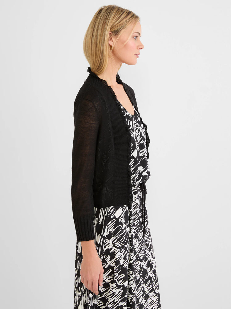 Black cardigan with ruffled trim along the opening and neckline, featuring light, semi-sheer sleeves.