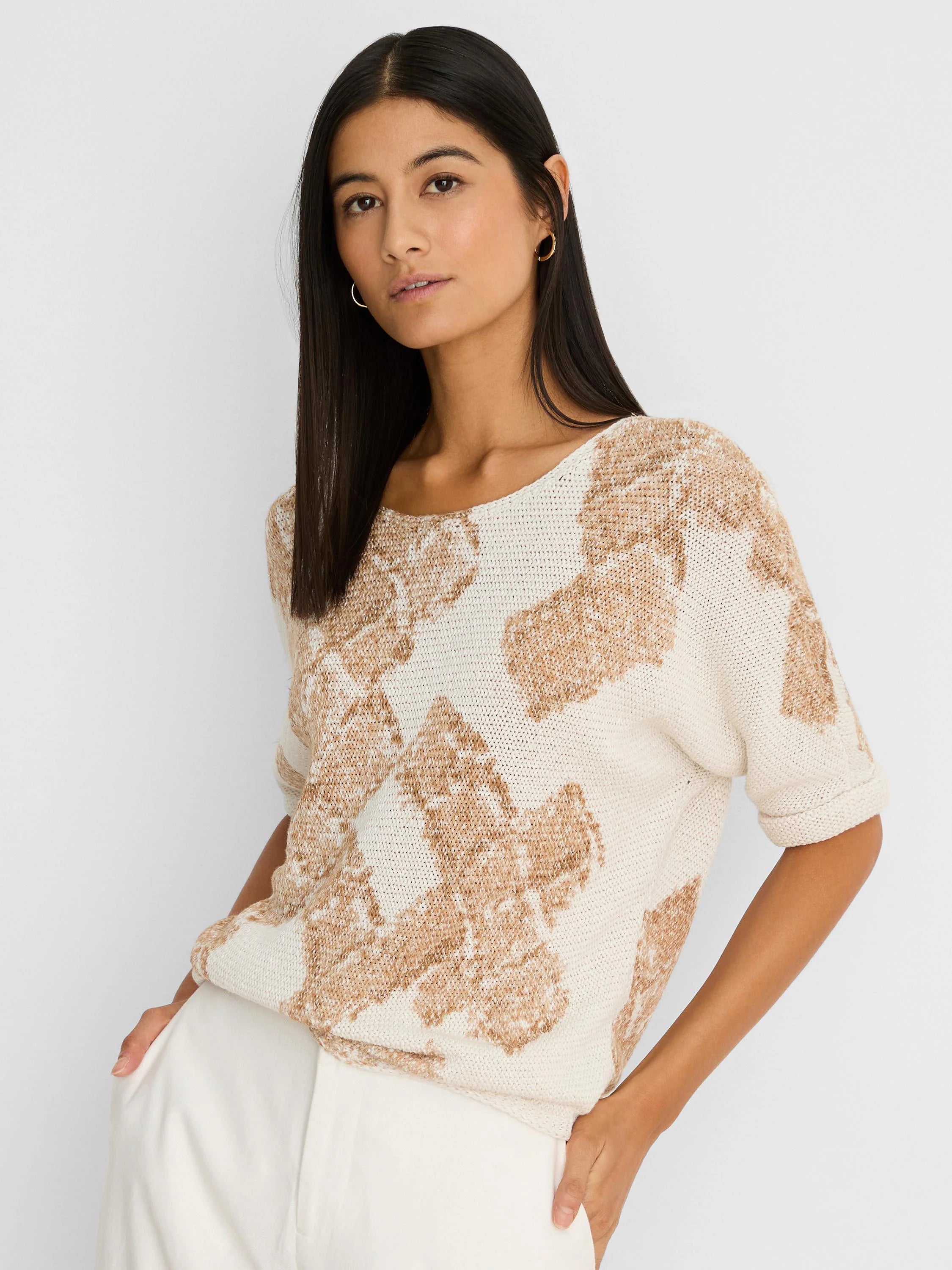 Off-white knit sweater with light brown cobblestone stamp pattern, boat neck, short sleeves, and rolled cuffs.
