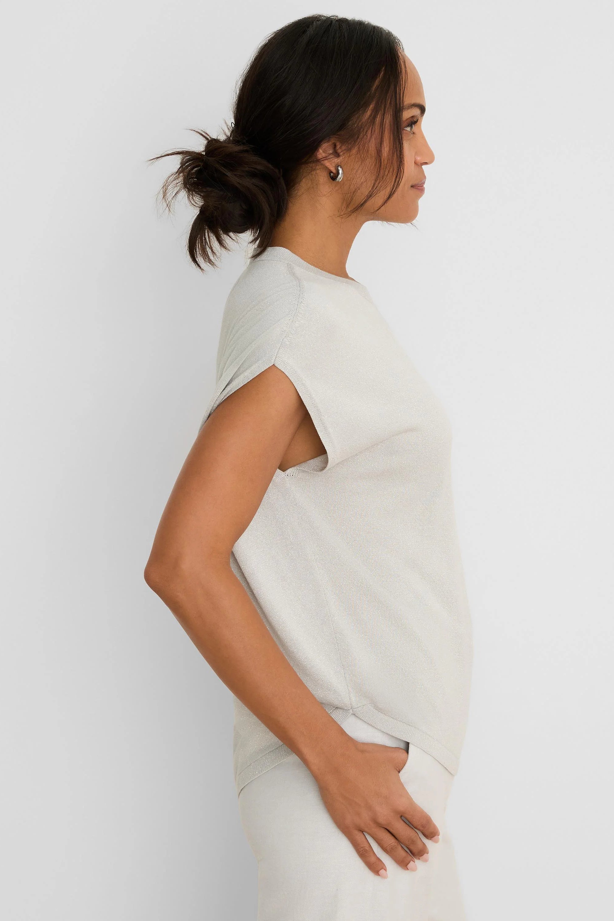 Shimmering pale gray-beige cocoon sweater with split short sleeves, worn by a model in profile.