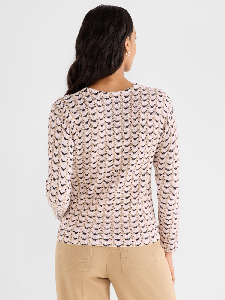 Slim knit sweater in pale pink featuring a chevron pattern knit in black and metallic gold, worn by the model from the back.