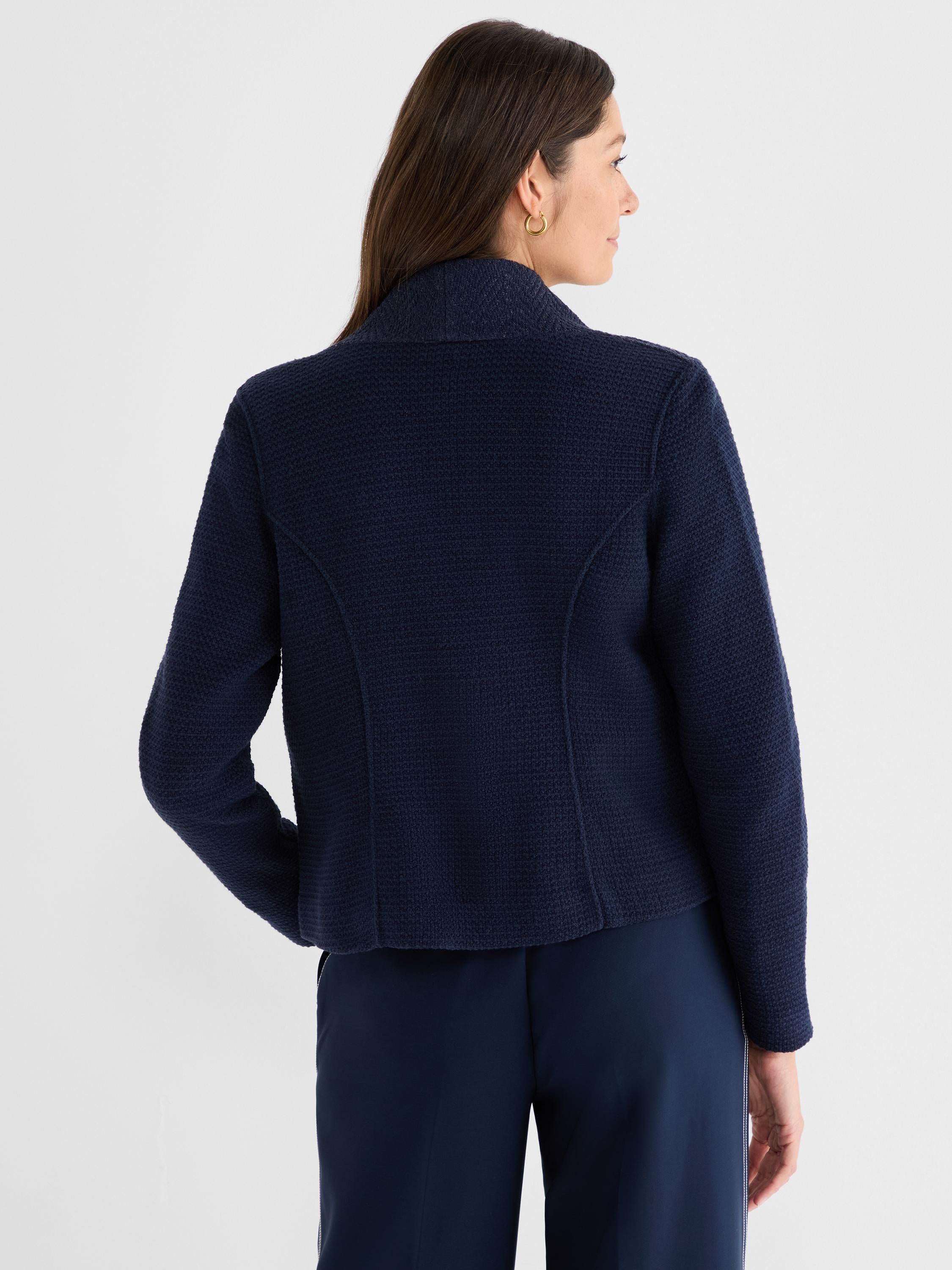 This dark blue textured jacket has a structured back seam detail, long sleeves, and a mock collar.
