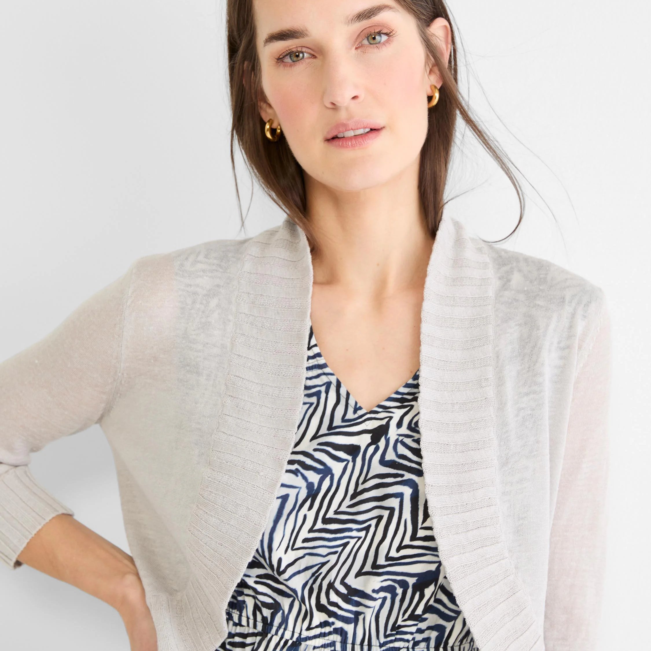 Light grey knit bolero cardigan with open front, long sleeves, and ribbed cuffs and front edges.