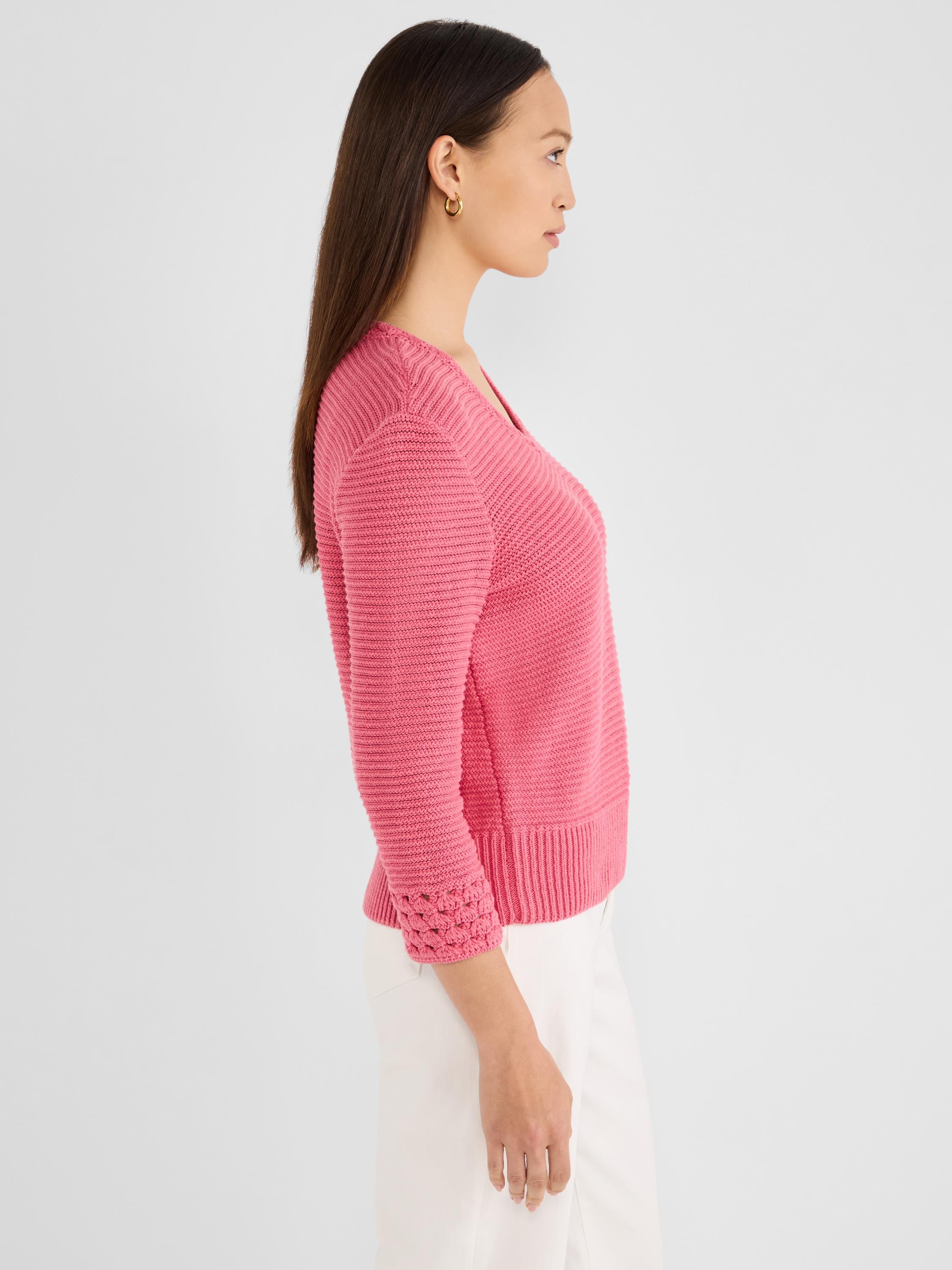 A hot pink textured V-neck sweater with three-quarter sleeves and open crochet cuff detail.