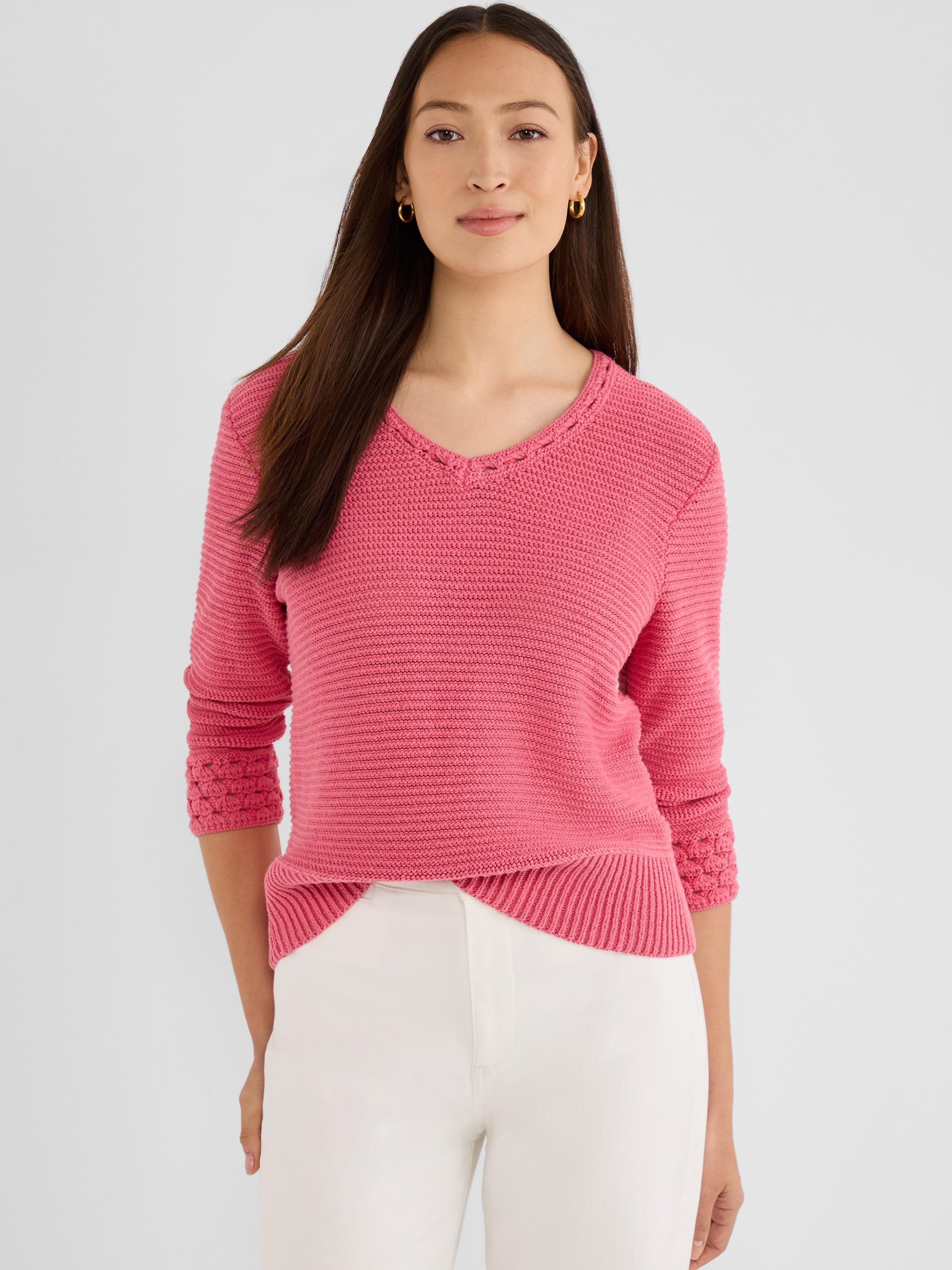 Relaxed pink textured knit sweater with a V-neckline and decorative crochet details on the three-quarter sleeves.