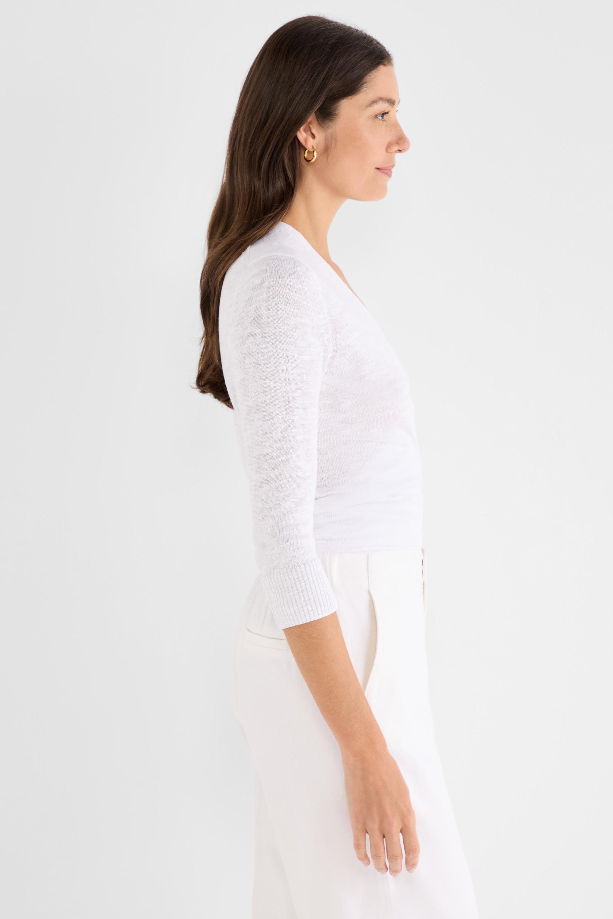 White lightweight knit top has a slim fit, V-neck, and three-quarter sleeves with ribbed cuffs.
