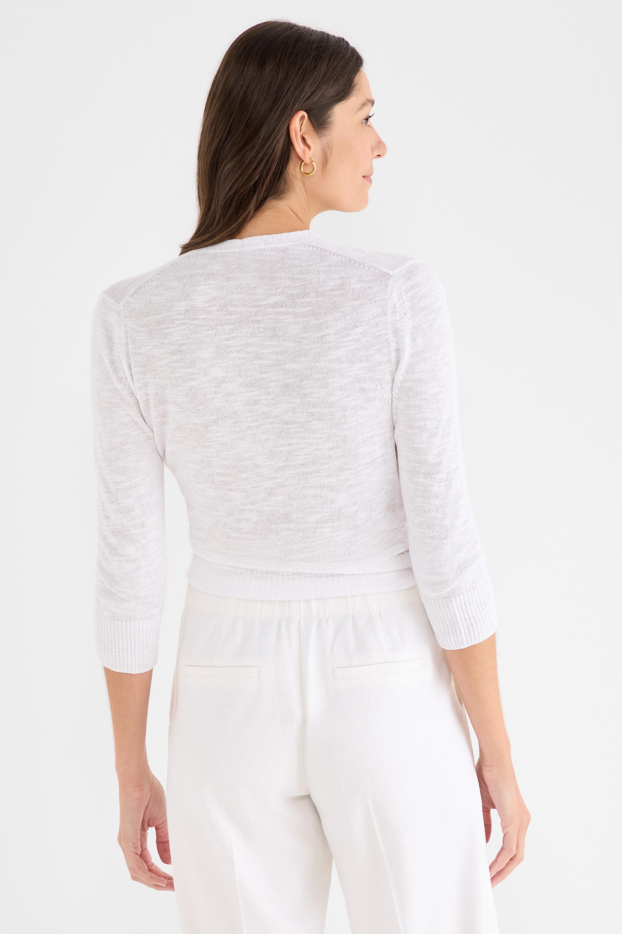 This fitted, cropped white cardigan features lightweight heathered knit fabric and three-quarter sleeves.
