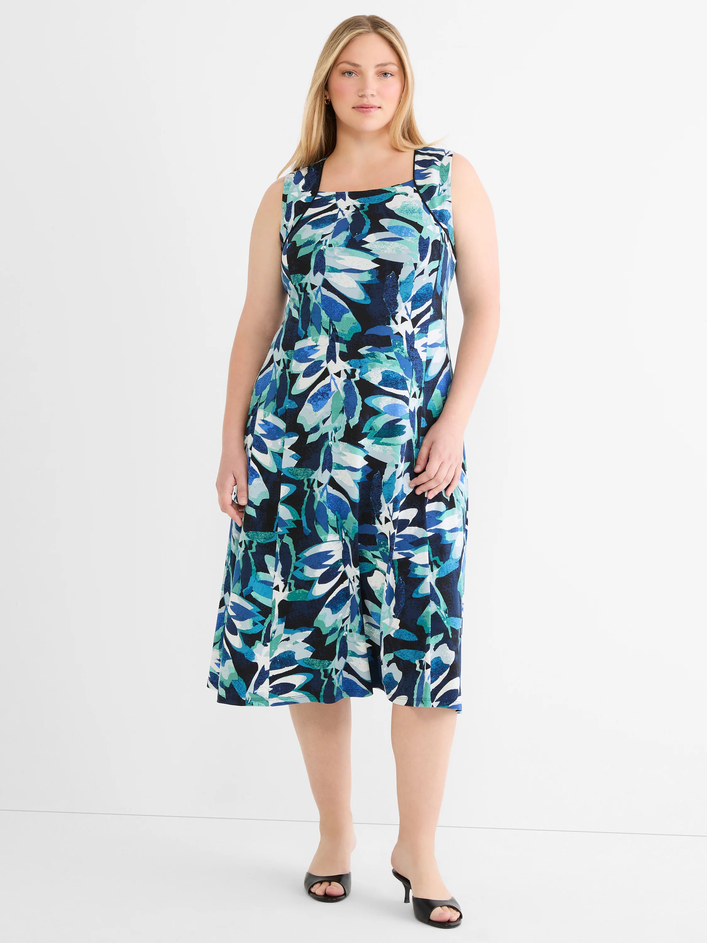 Sleeveless midi dress with square neck and blue, teal, white abstract leaf pattern on a dark background.