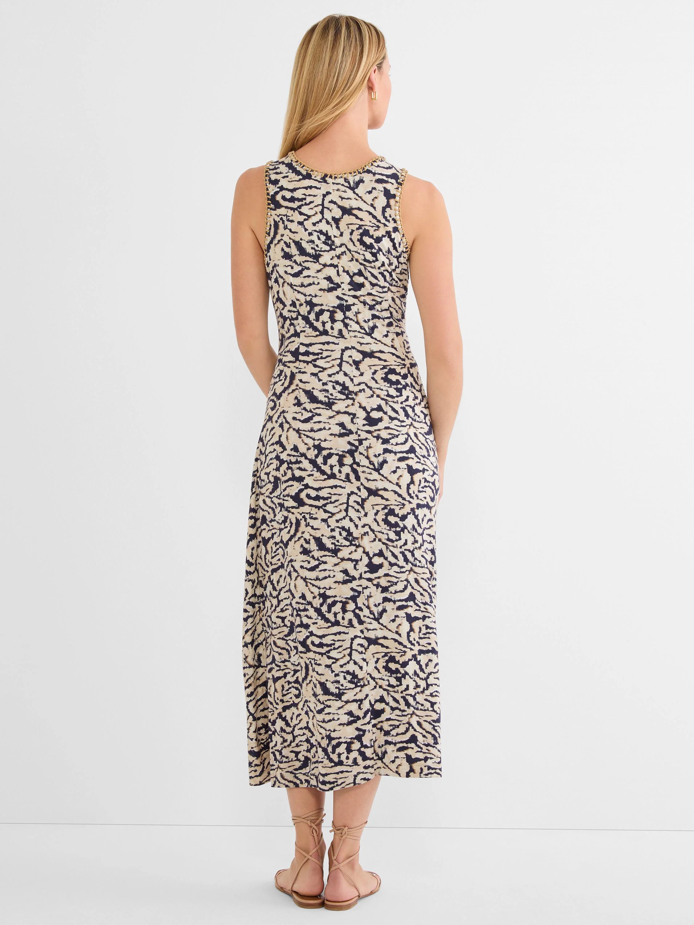 Back view: Sleeveless midi dress. Dark navy swirl pattern on light beige heather fabric. Tan braided trim at neckline.