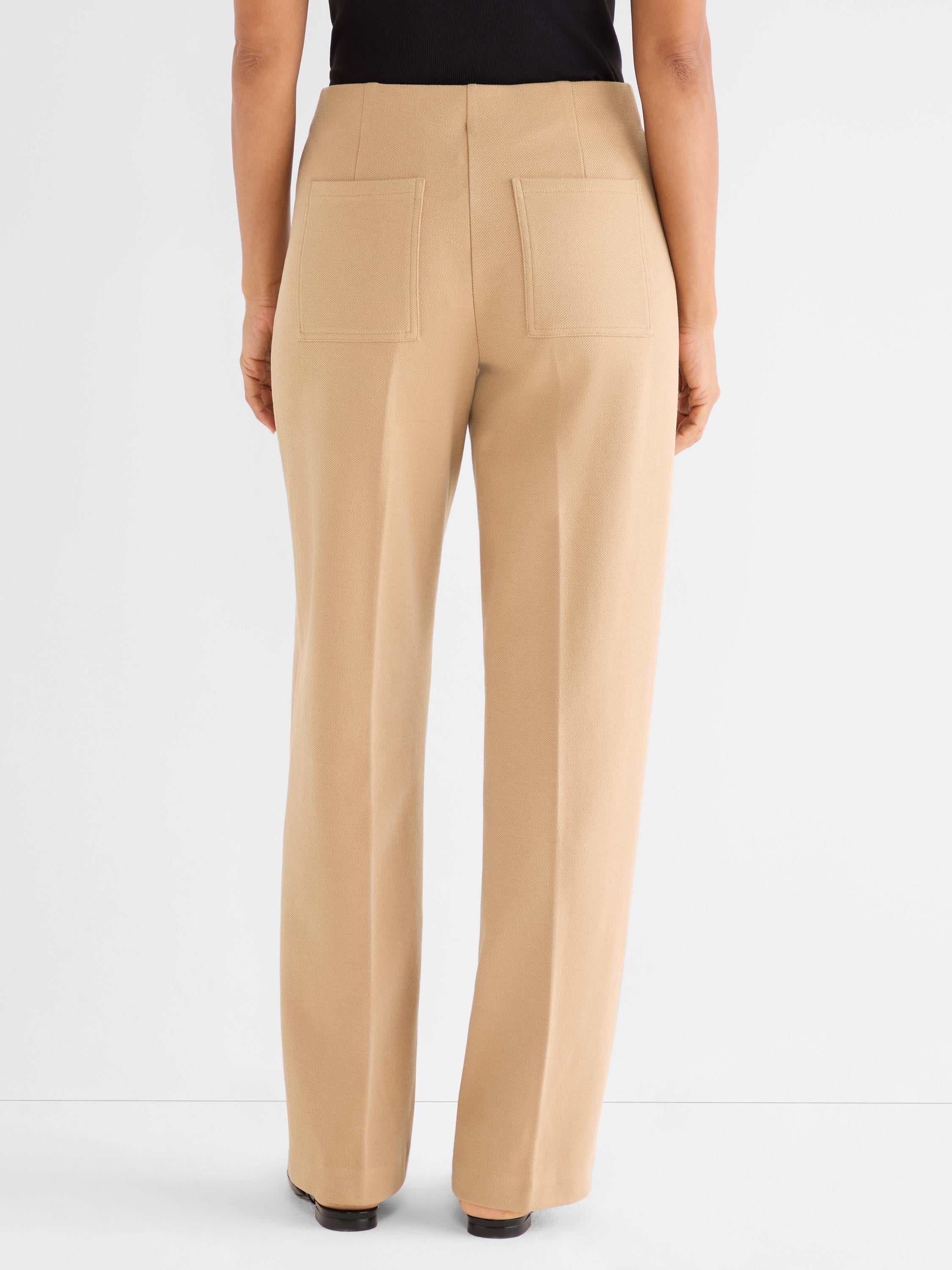 High-waisted tan trousers with a straight leg fit are shown from the back, featuring large patch pockets.