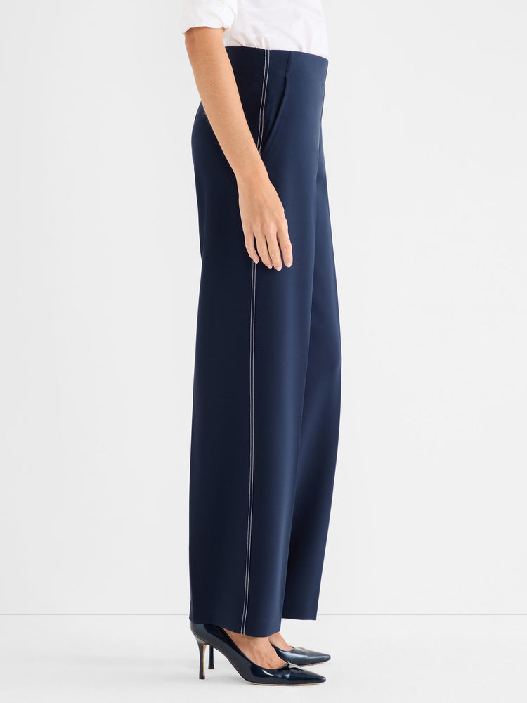 Navy high-waisted wide-leg trousers with white contrast stitching detailing the outer seams.