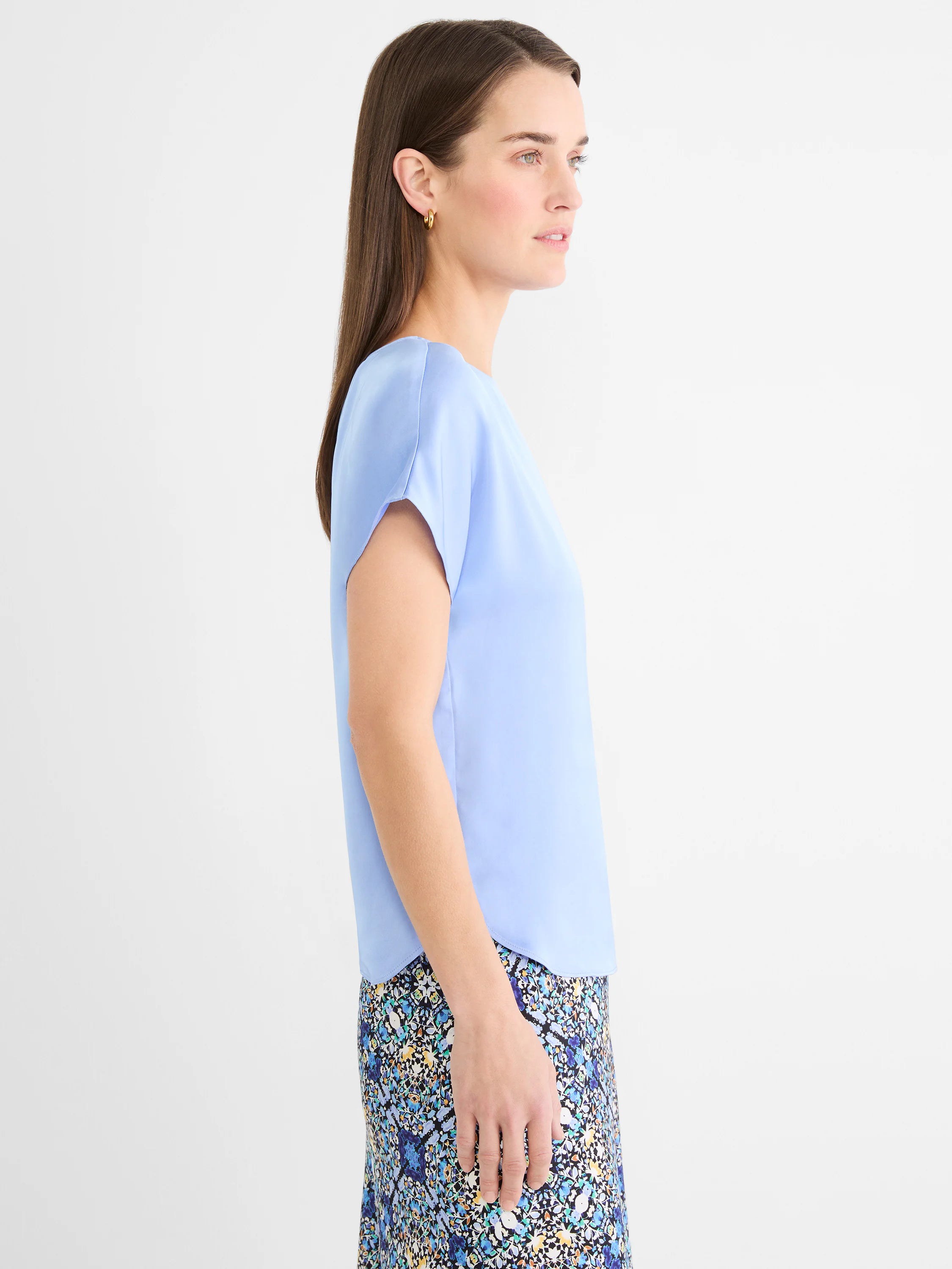 Pale blue smooth woven tee with loose cap sleeves and a curved hem.