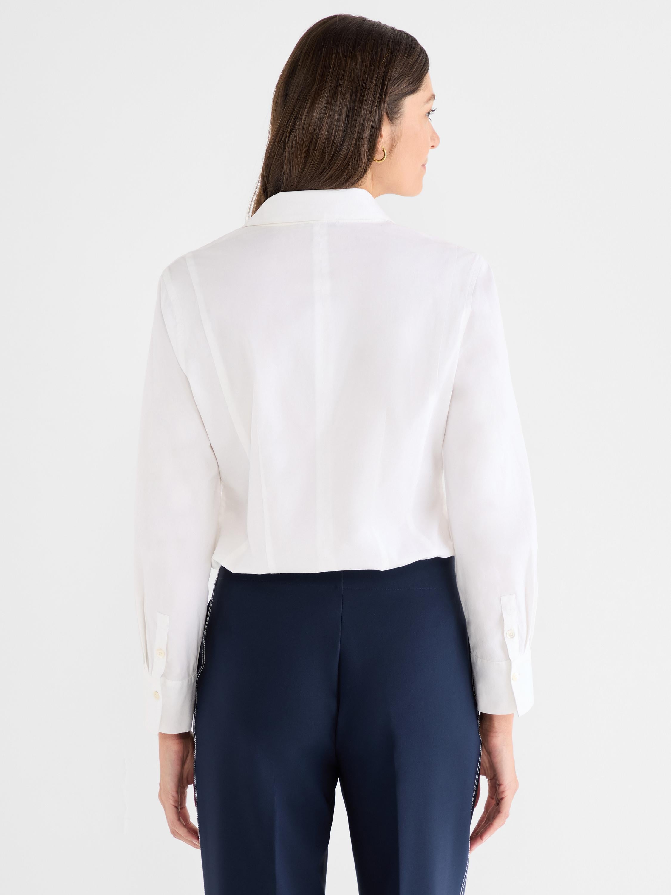 The model wears a crisp white long-sleeve button-down shirt with a classic collar and cuffs, shown tucked in.