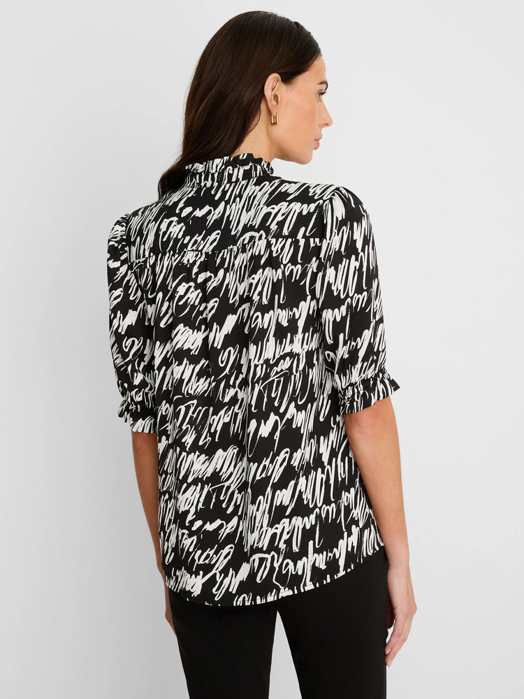 Black and white top with abstract cursive pattern, high ruffled neck, and gathered short sleeves.