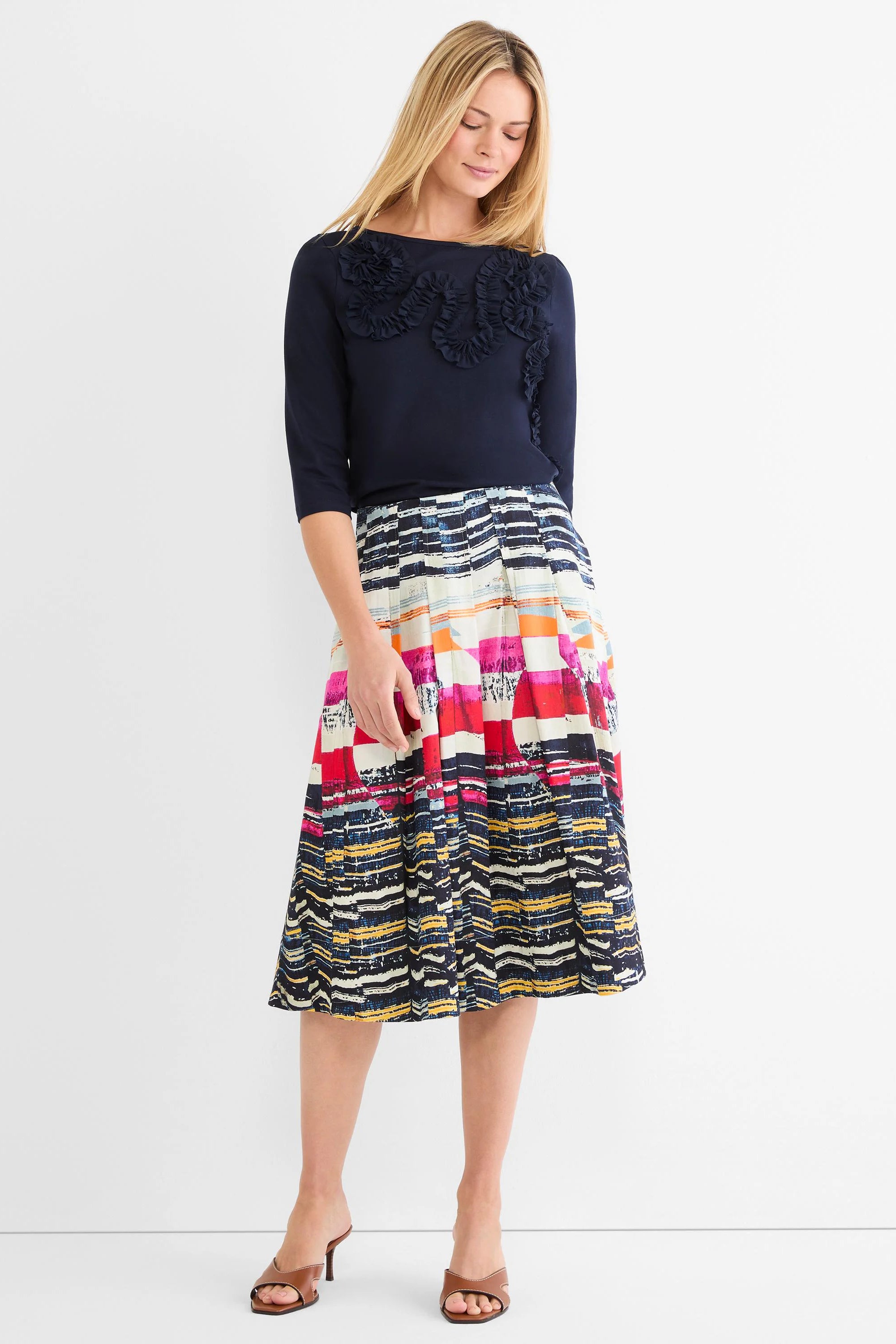 Pleated midi skirt with colorful, abstract horizontal stripes in red, orange, yellow, pink, and shades of blue.