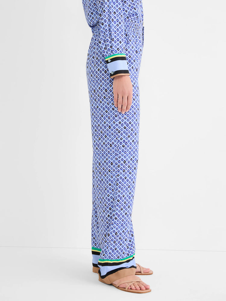 Wide leg pants, blue mosaic pattern with black/gold accents. Hem has tan, light blue, black, green, yellow striped trim.