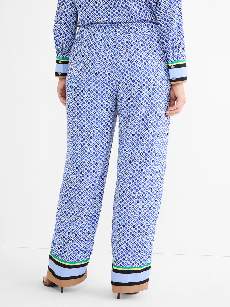 Blue mosaic wide-leg pants with green, yellow, black, light blue, and tan striped trim on hems.