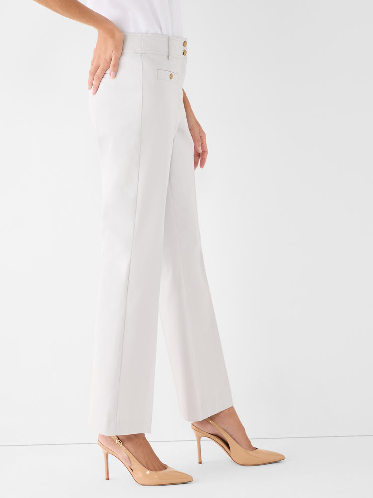 Cream high-waisted trousers with exposed gold buttons and a straight-leg fit are worn by the model.