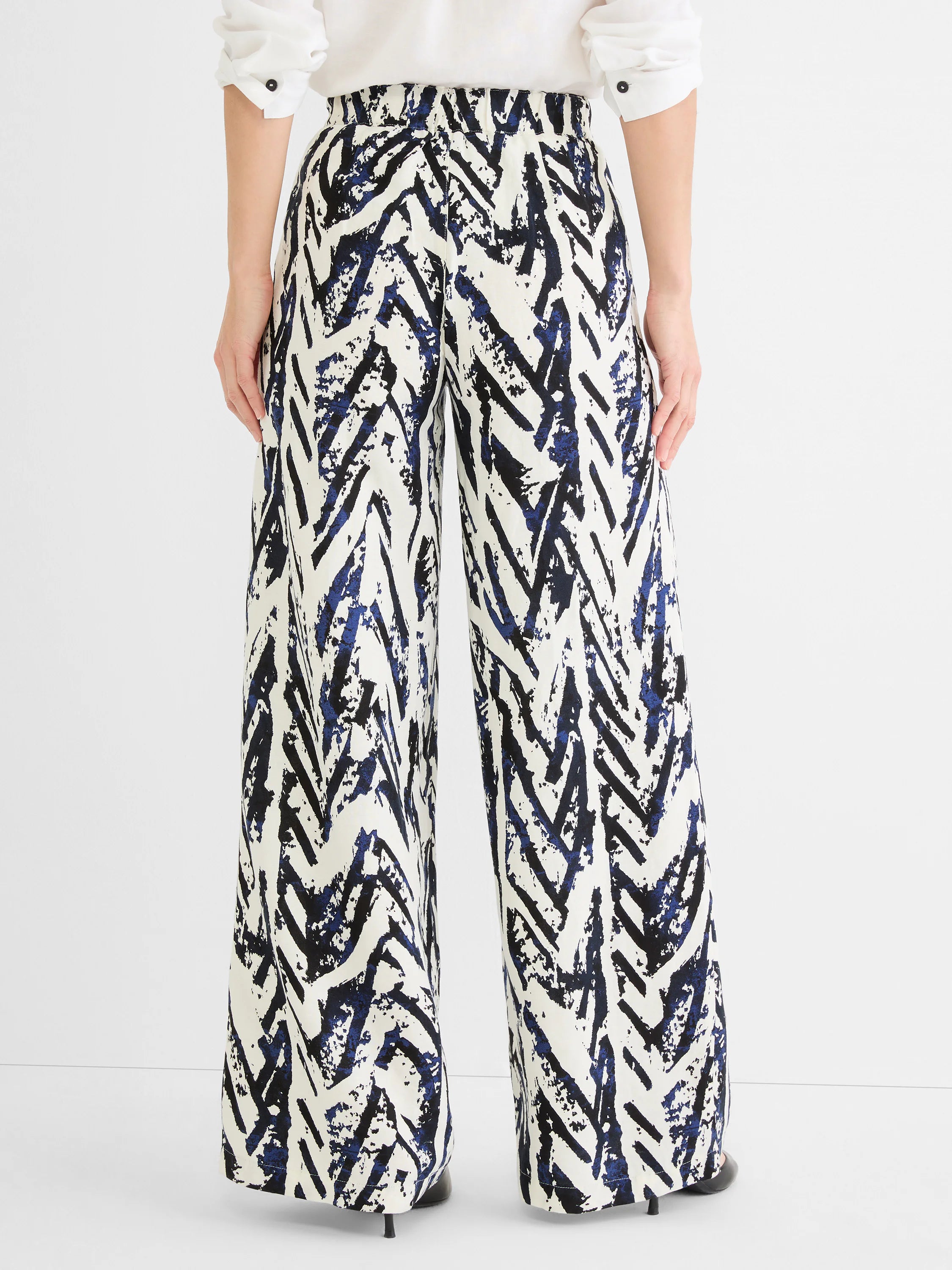 White wide-leg pants with abstract black and indigo crosshatch pattern. Gathered waist.